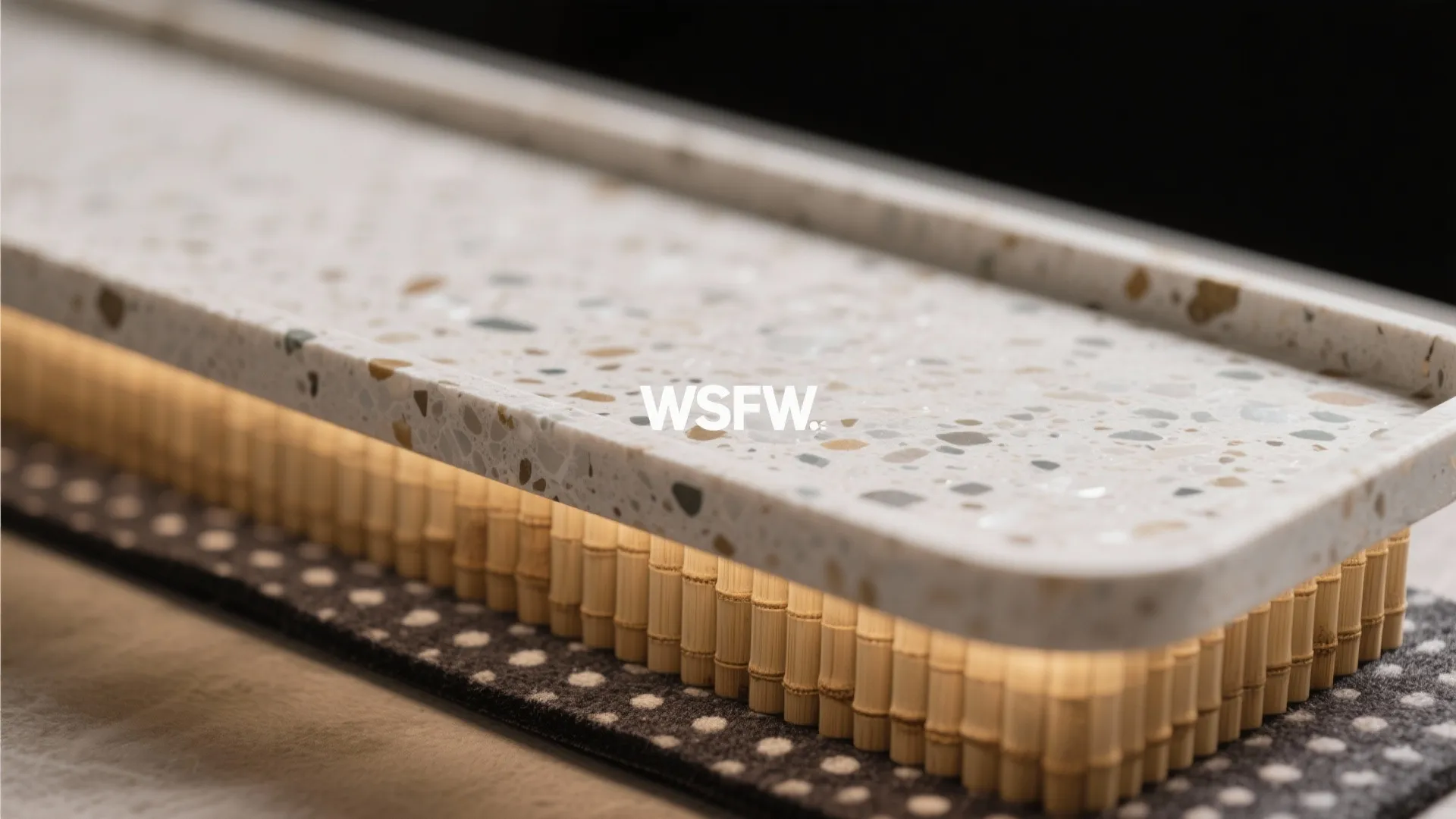 Macro of terrazzo tray surface with ribbed insert lifting the soap bar.