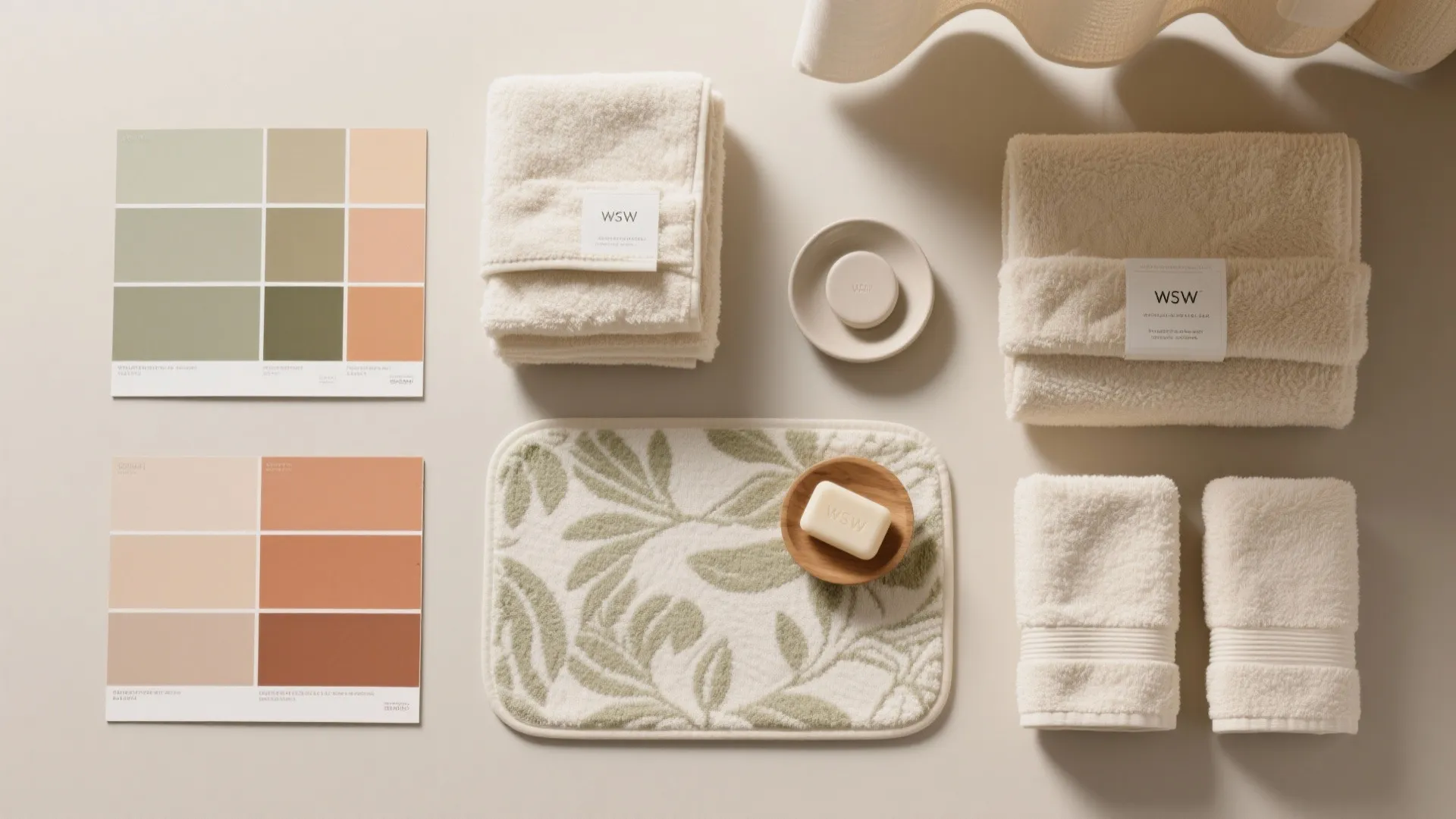 Flat lay of bathroom accessories with beige towels soap green pattern rug and color swatches