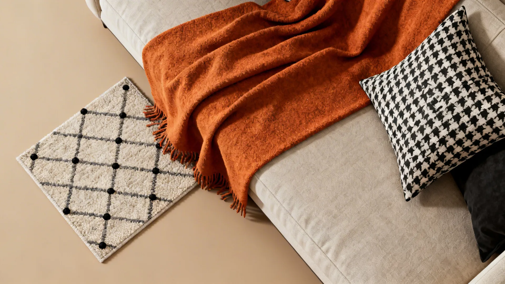 Flatlay of burnt orange throw, black-and-white pillows and geometric rug swatches