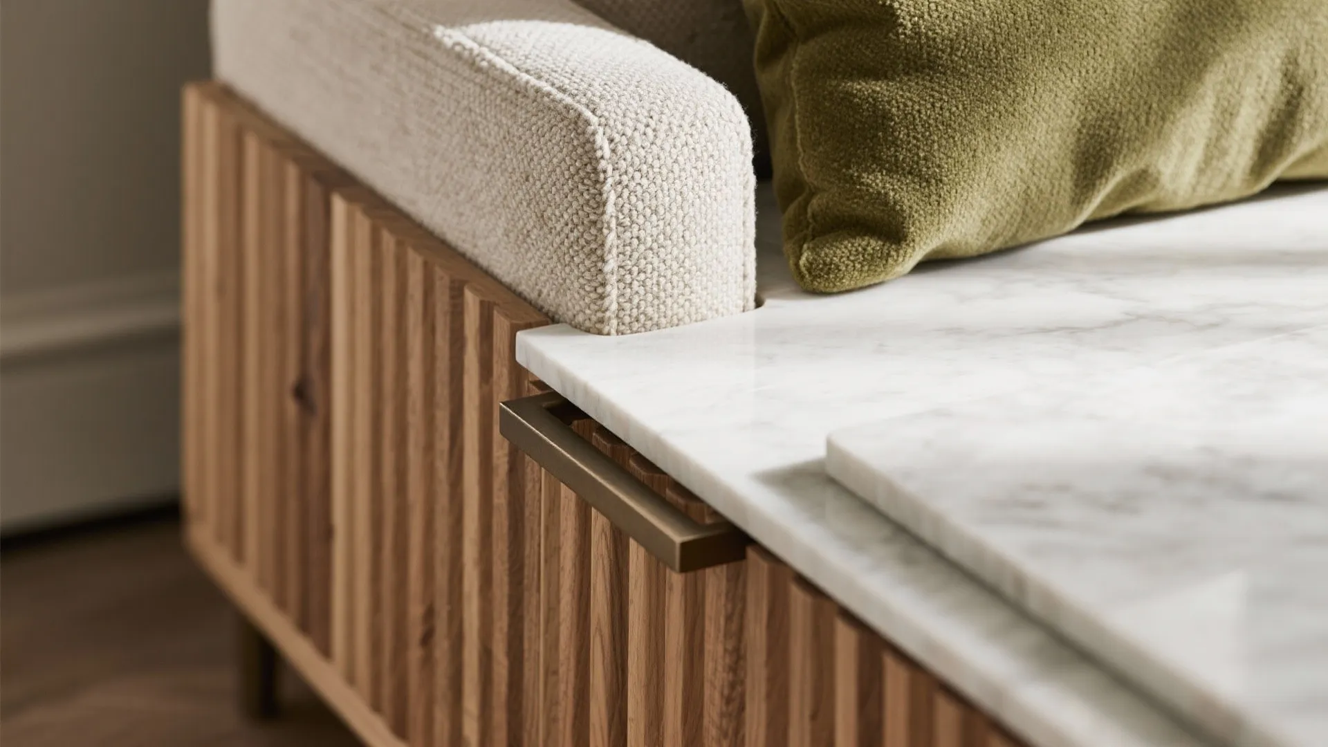 Close up of a marble top cabinet with wood wall panel details and soft cushions