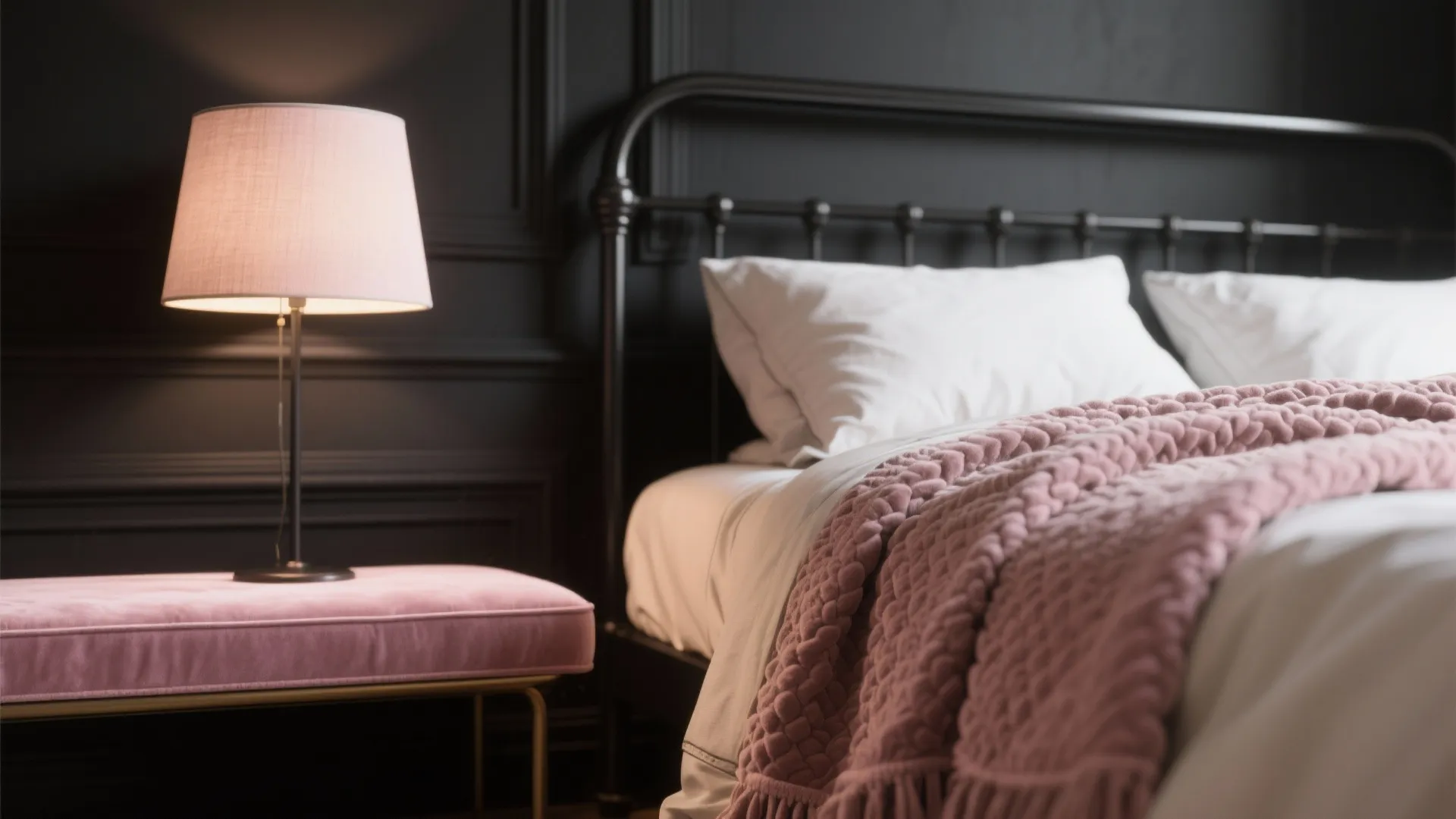 Modern bedroom with black wall metal bed frame pink blanket table lamp and soft pillows