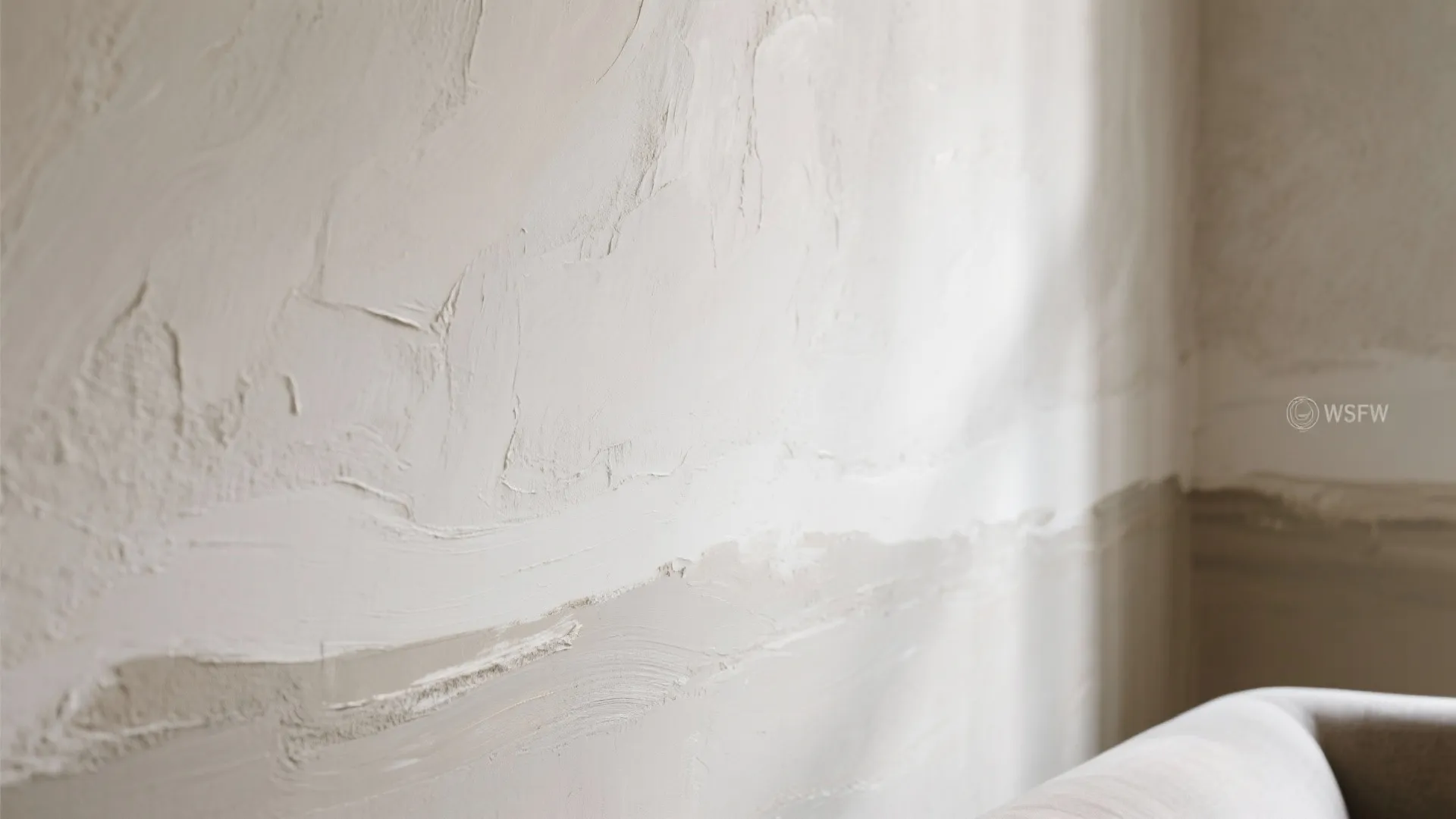 Close up view of white textured wall paint showing rough surface details in a bright room