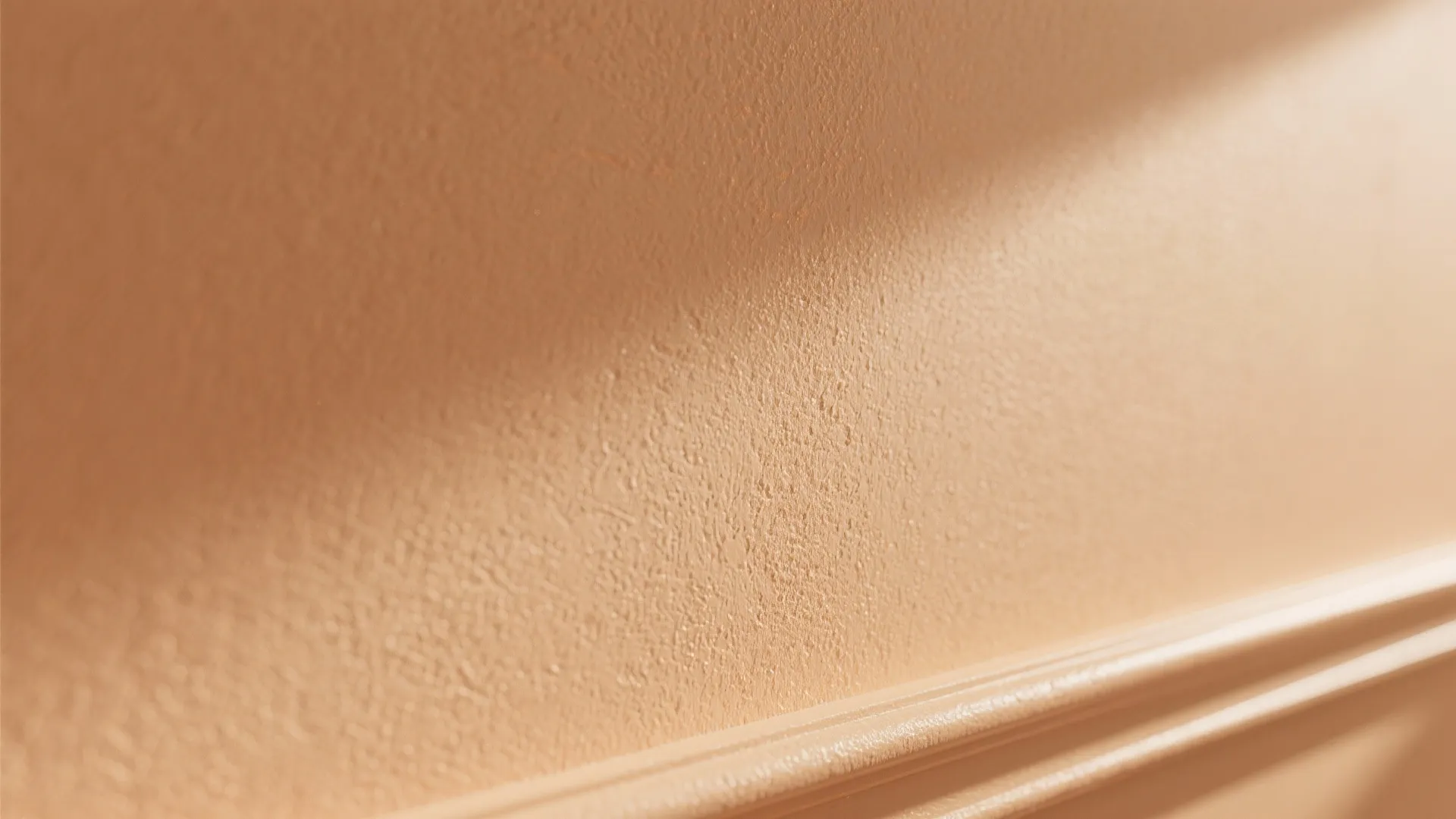 Close up shot of a light peach wall with rough surface texture and wall panel