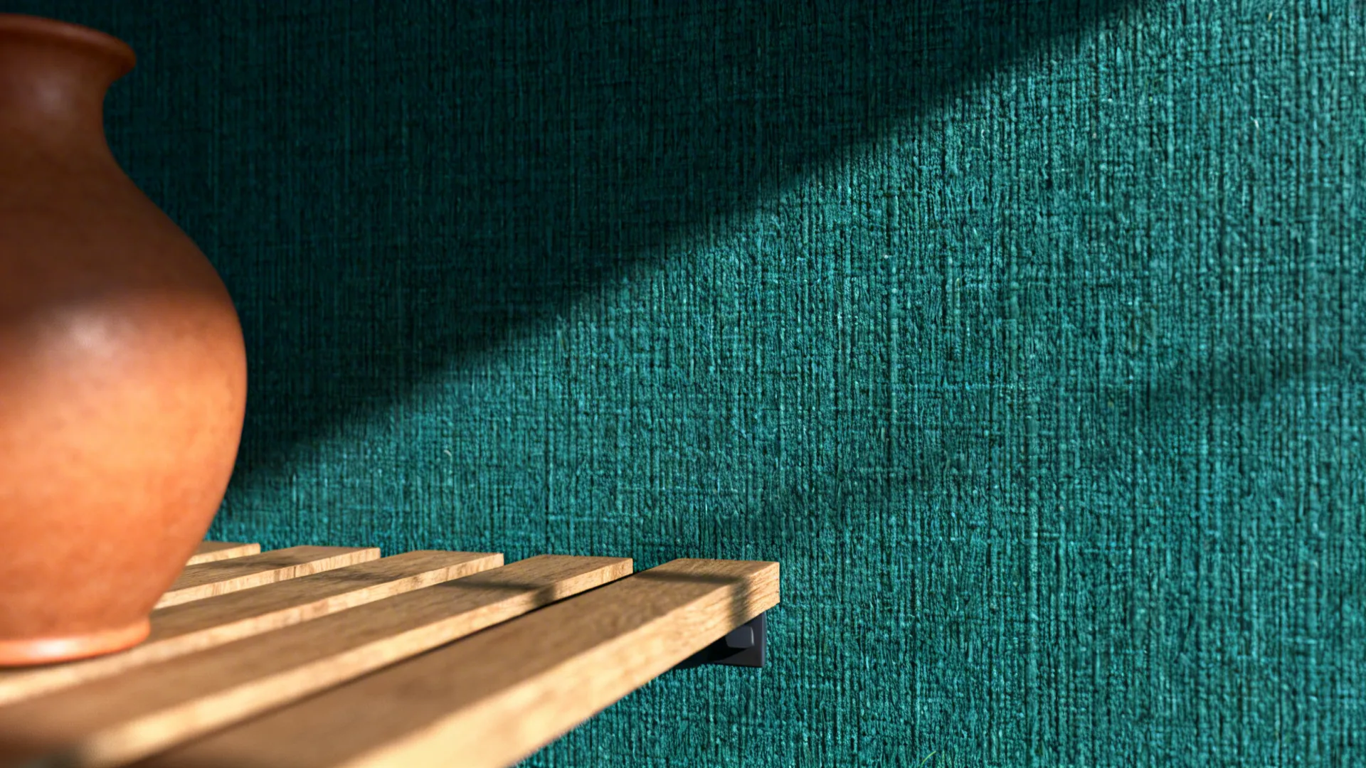 Macro view of deep teal grasscloth accent wall with wooden shelf and terracotta vase.