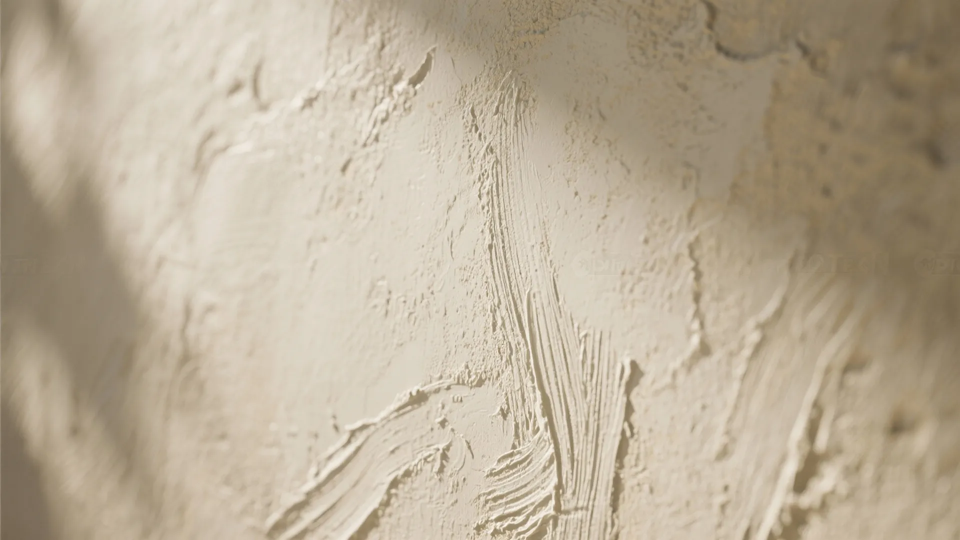 Close up of cream colored textured wall paint showing rough brush strokes and soft shadows