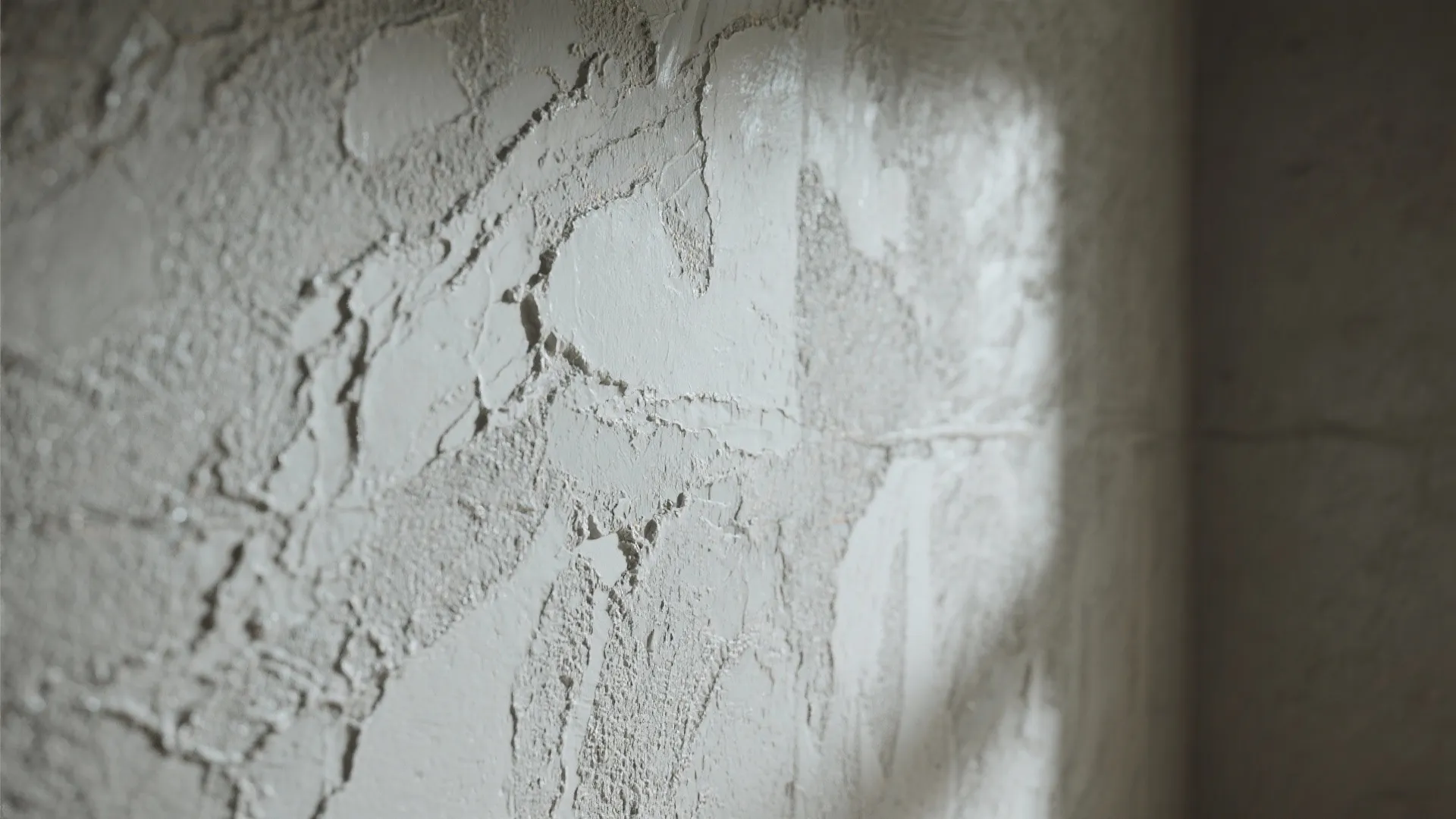 Close up of grey textured wall with rough surface and soft natural light from window