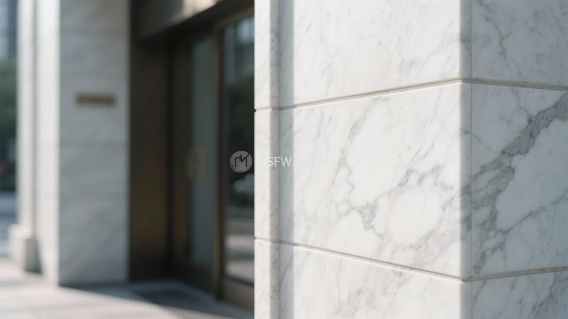 White marble wall tiles with grey veins on the corner of a modern building exterior