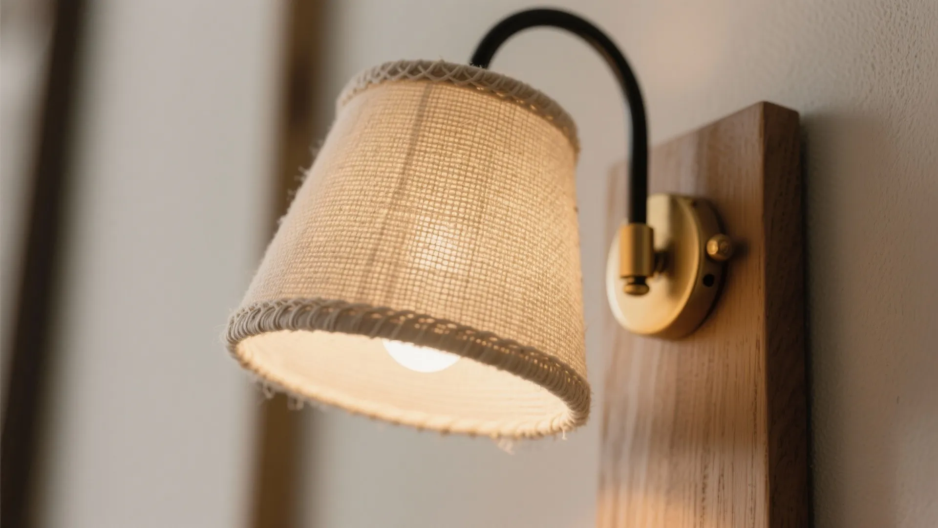 Macro of linen-textured sconce shade glowing warmly with soft diffusion.