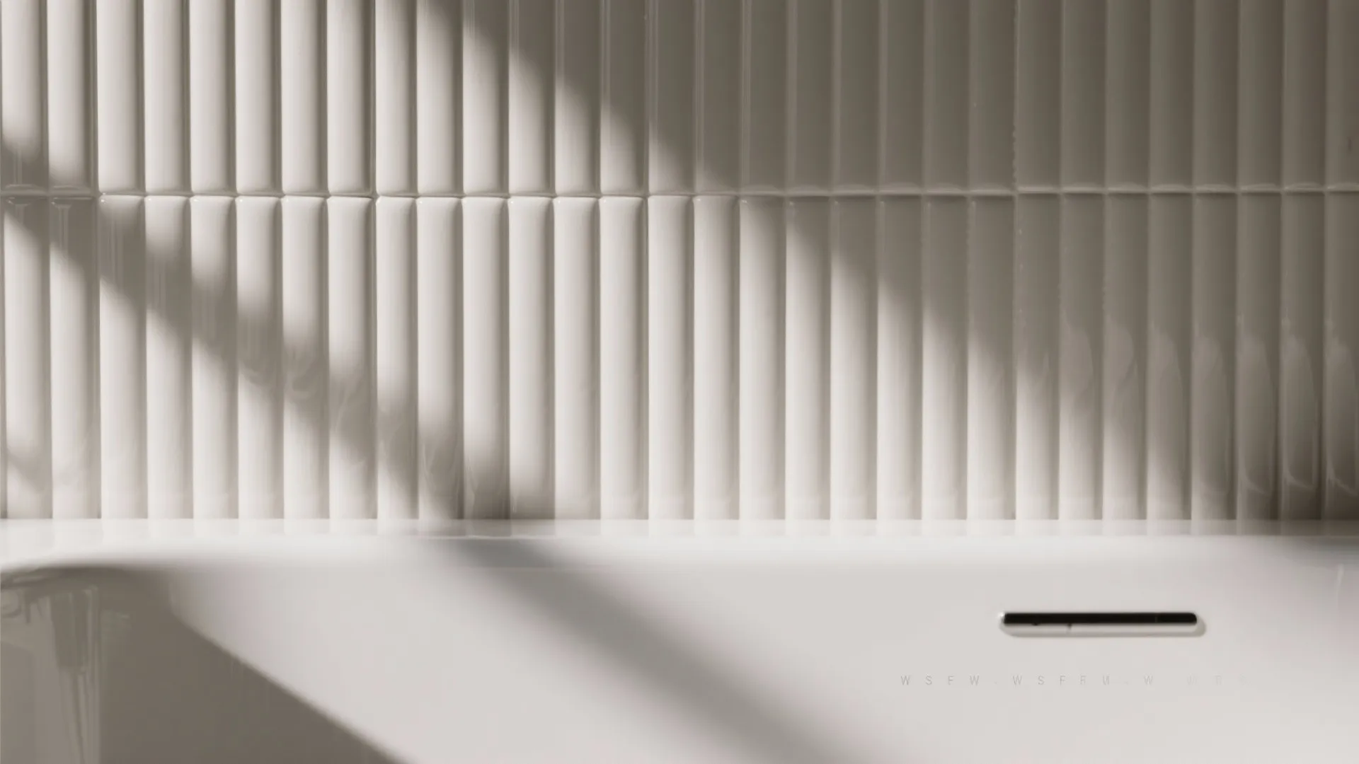 Macro of fluted porcelain tile behind a white tub with gentle light and shadow.