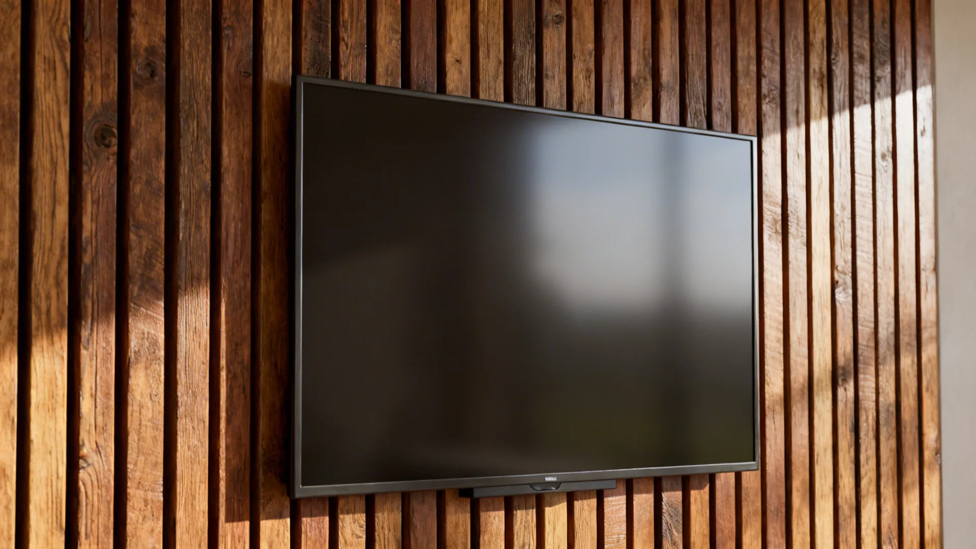 Close-up of reclaimed oak slats used as a textured backing behind a wall-mounted TV.