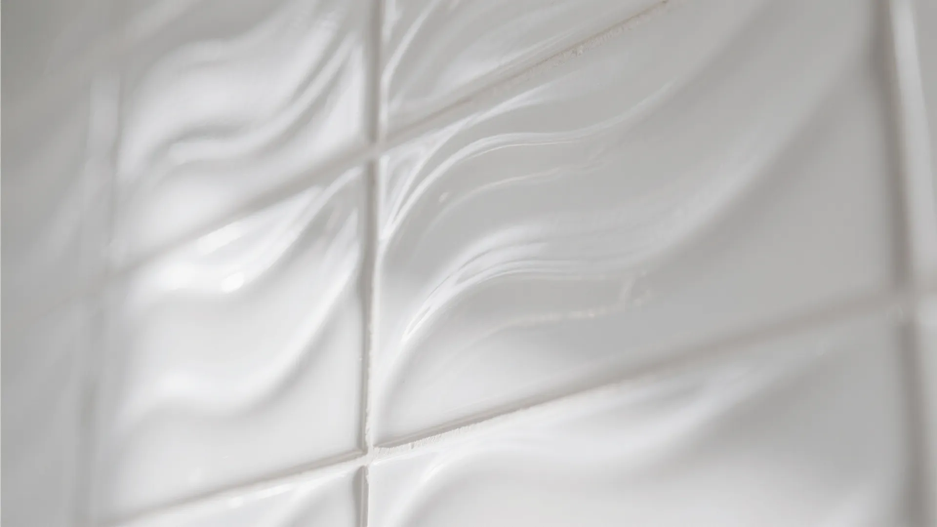 Close up shot of textured white wall tiles with a wavy 3D surface design pattern