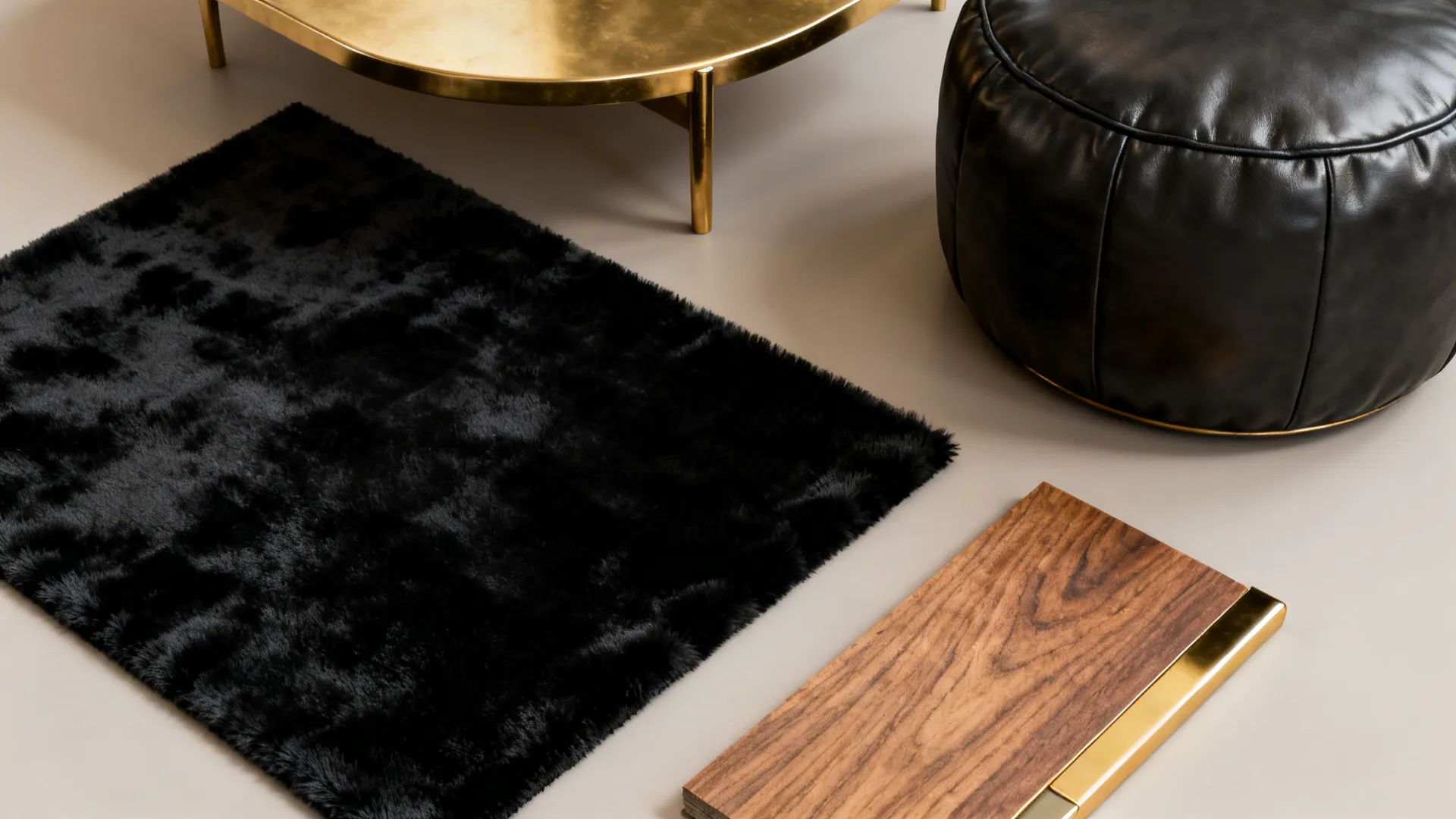 Flatlay of black velvet, dark leather, and brass samples showing tactile variety for a luxe small living room.