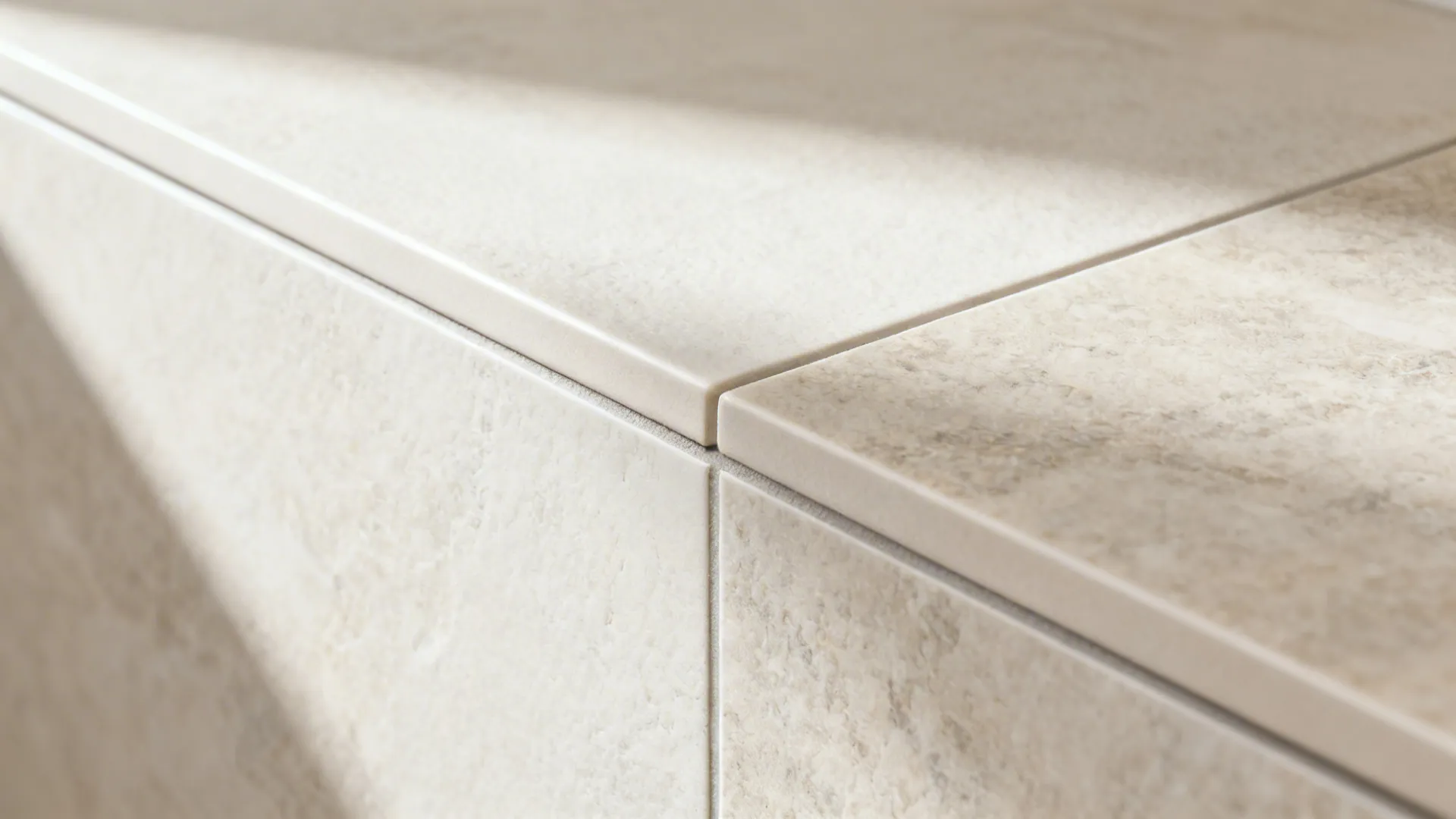 Macro of porcelain tile with a precise thin grout joint and subtle stone texture.