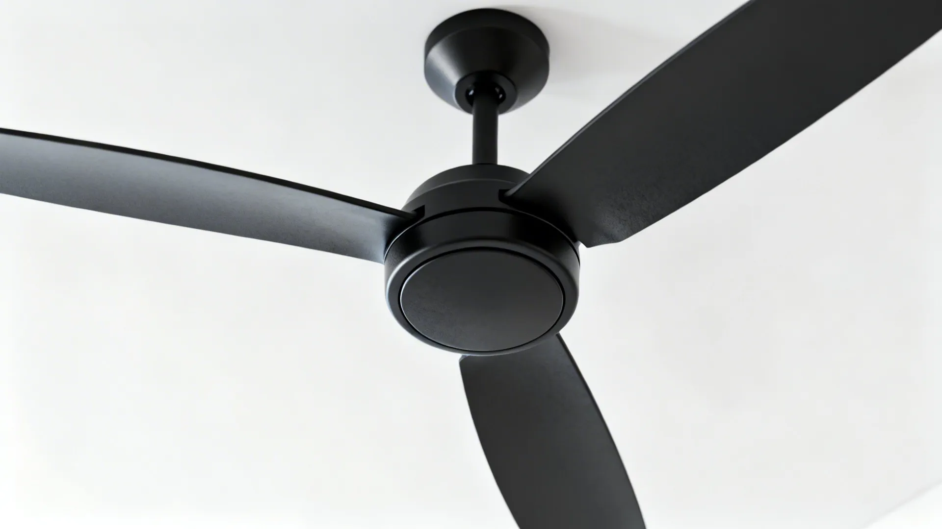 Close-up of a compact three-blade modern ceiling fan in matte black showing aerodynamic blade design.