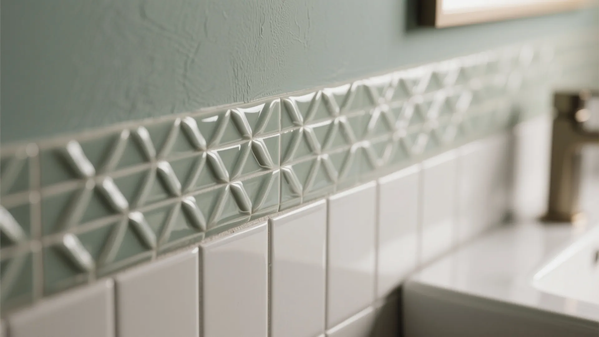Close-up of light green patterned wall tiles above white square tiles in a modern bathroom