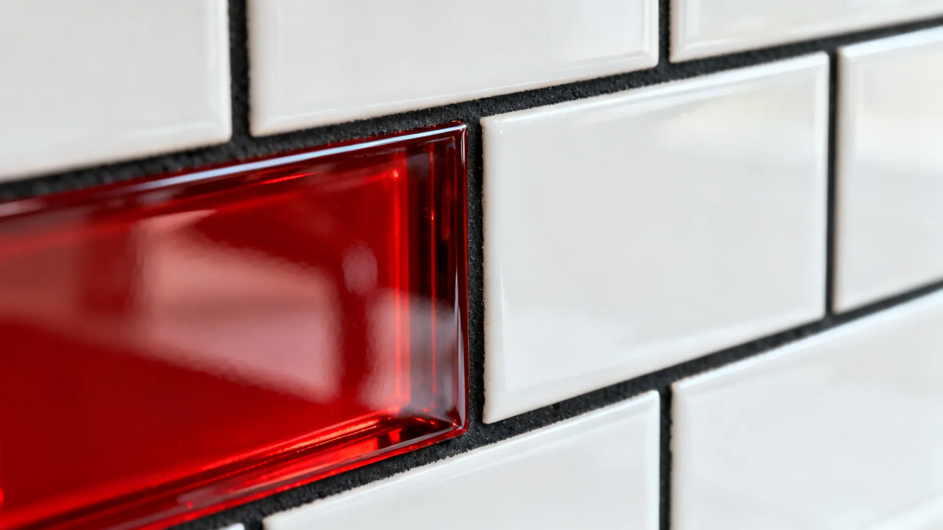 White cabinets, black grout, and a red glass backsplash