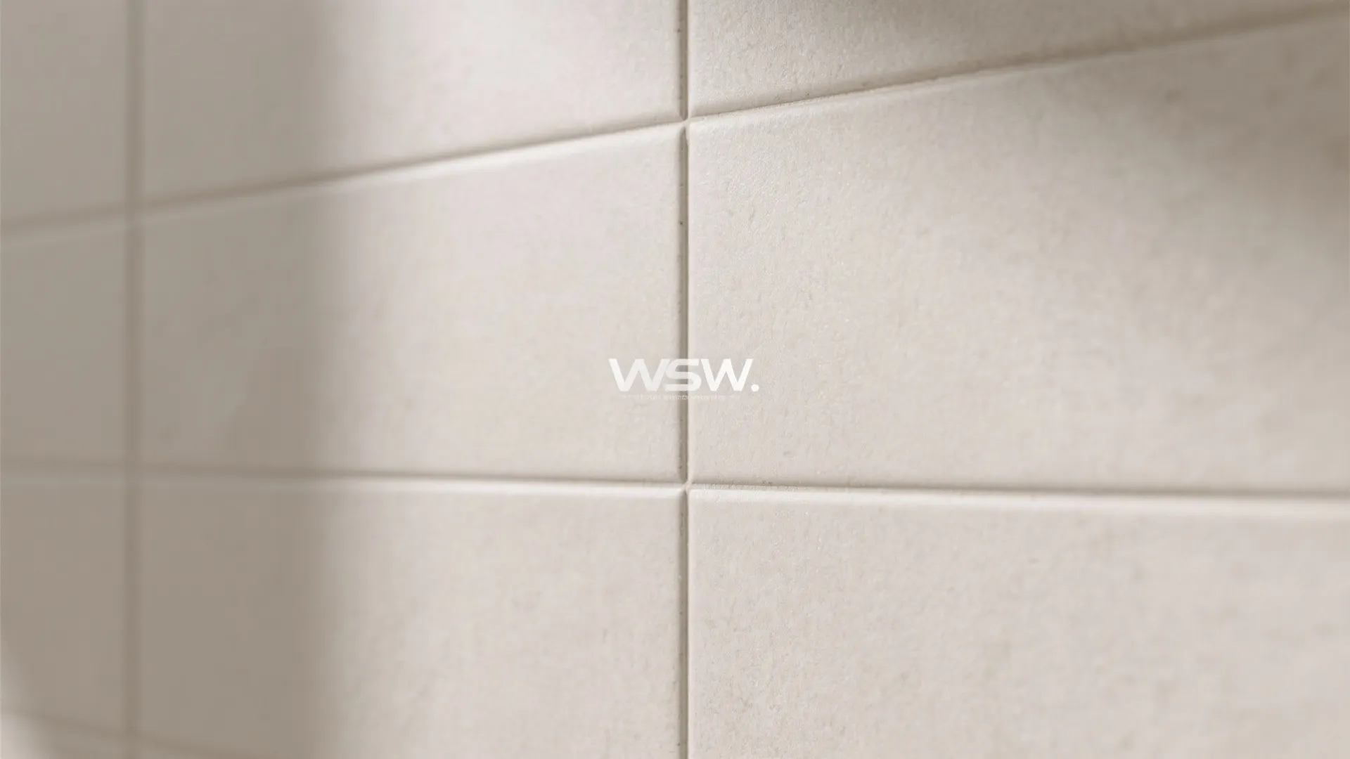 Macro of large-format neutral tile with light-wash grout and soft matte texture.