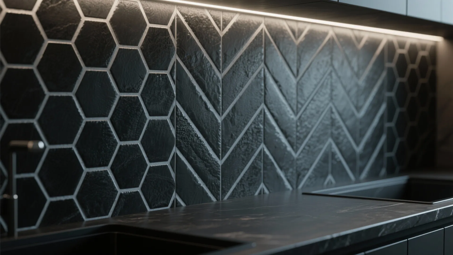 Black kitchen wall tiles with hexagon and chevron patterns under bright warm light fixture strip
