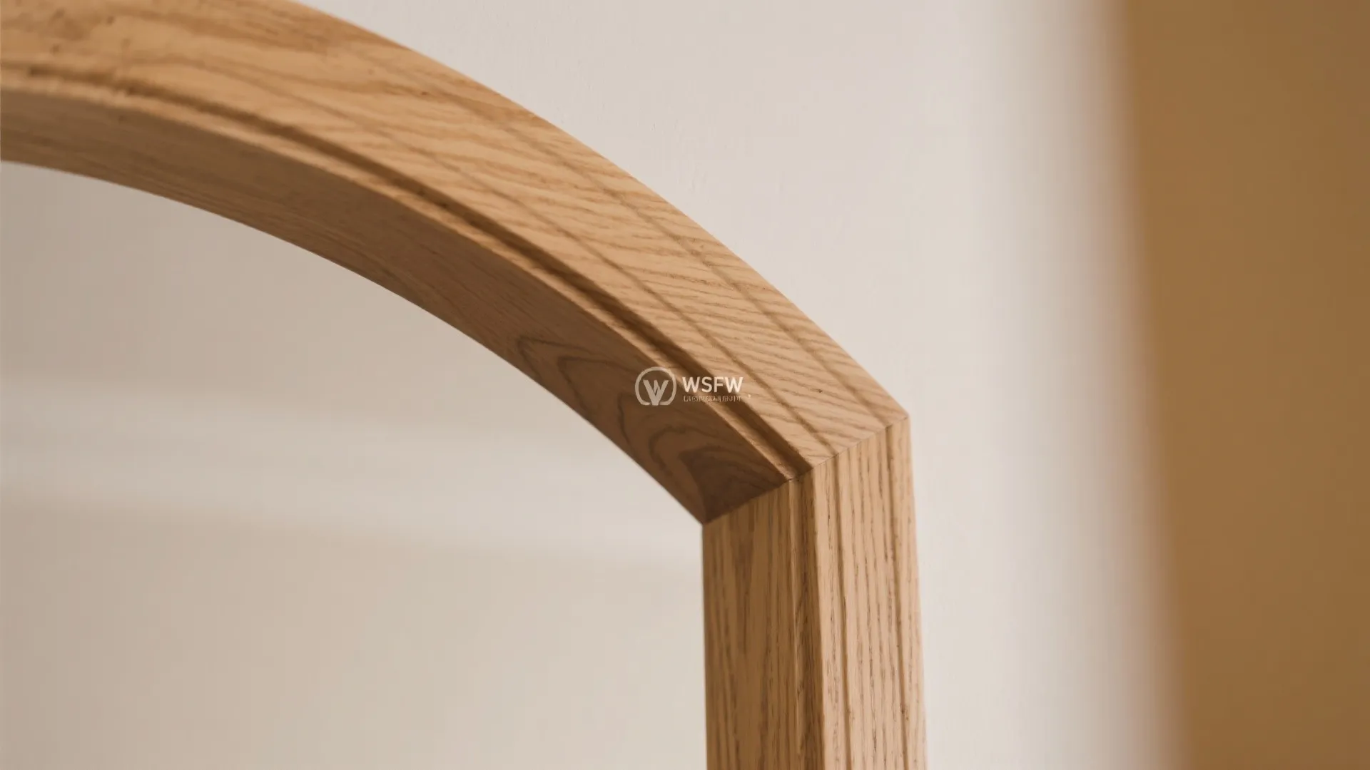 Close up view of a curved wooden door frame showing natural wood grain and smooth finish