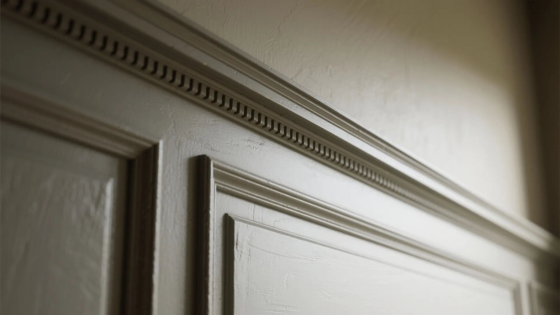 Close-up of moulding painted a few shades darker than the wall, showing texture and matte trim finish.