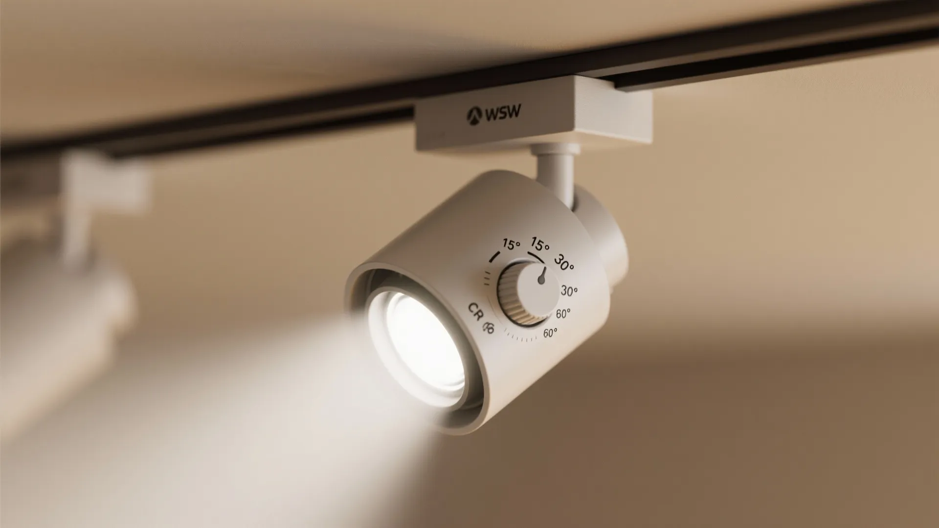 Close up view of a white adjustable spotlight attached to a black ceiling light track
