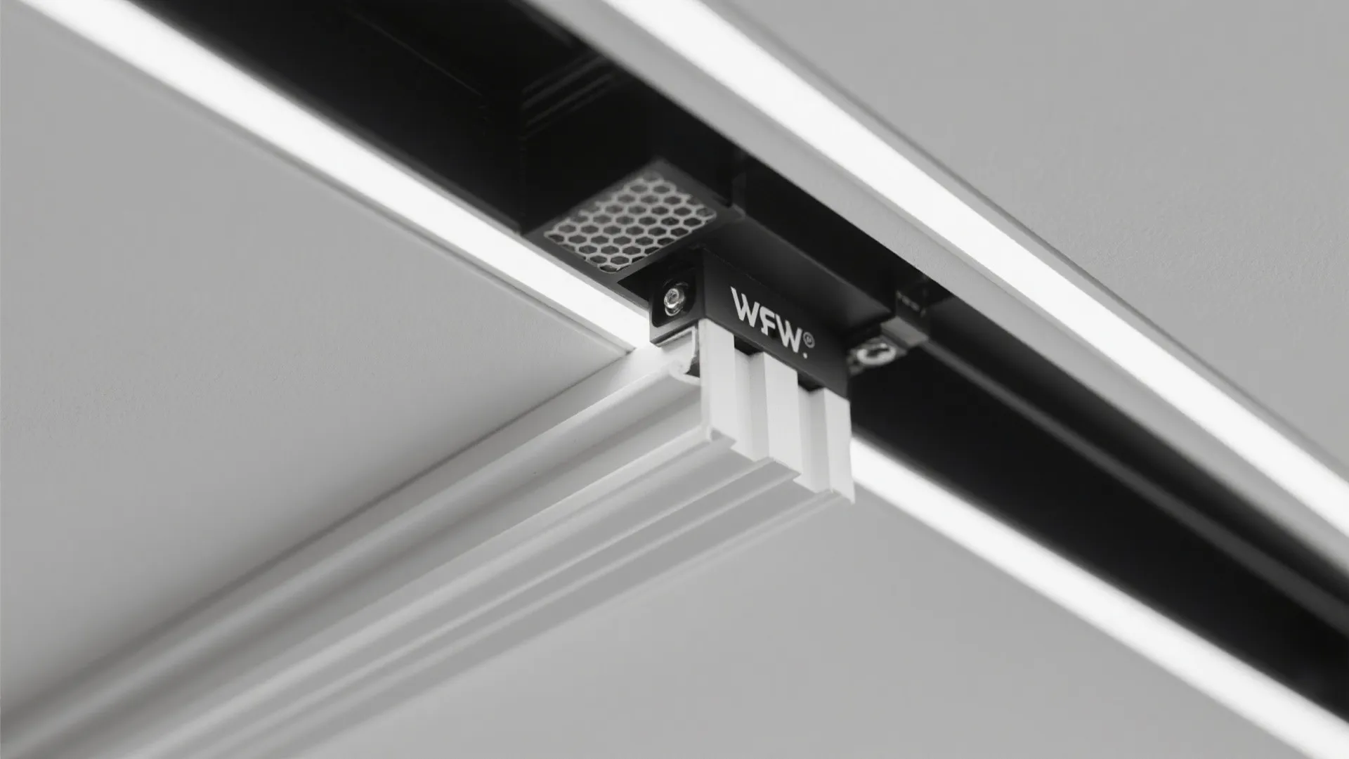 Close-up of white plastic light fixture part attached to a black track on a ceiling