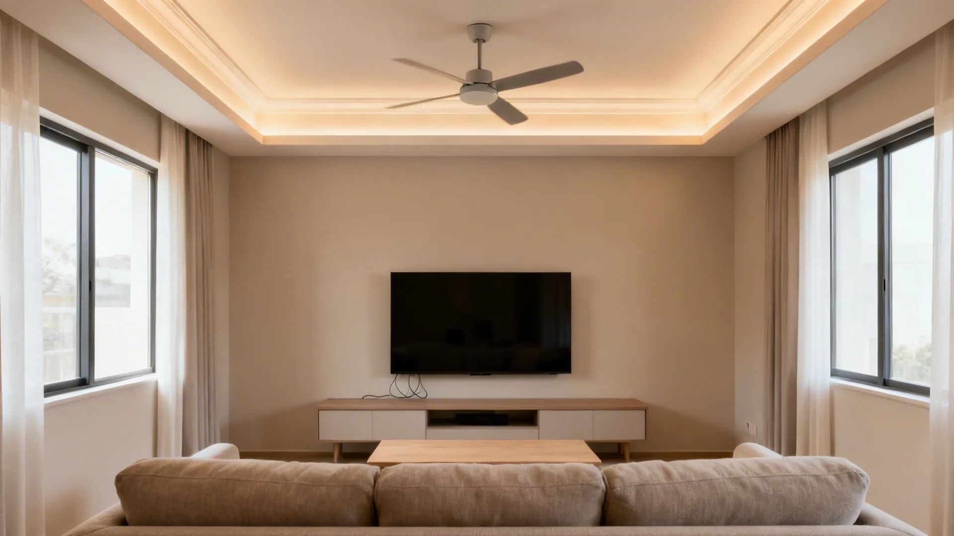 Shallow tray ceiling with warm cove lights and a centered ceiling fan in a small living room.
