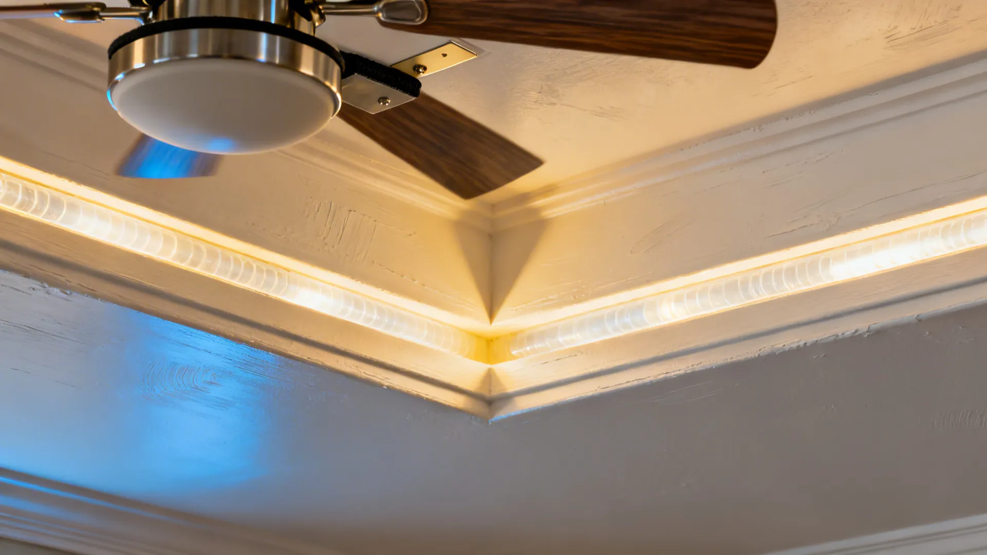 Macro of a tray ceiling cove light detail and fan canopy junction.