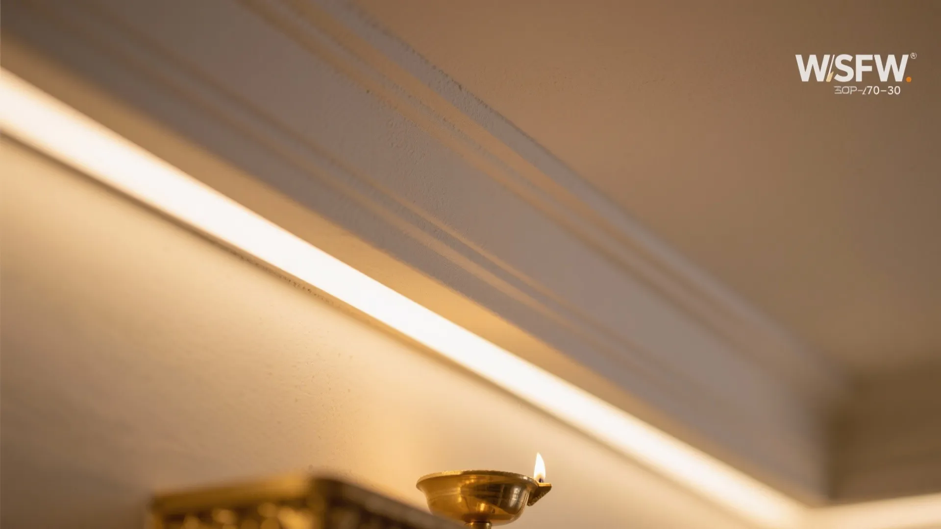 Modern ceiling lighting strip installed along wall panel with warm light and small metal bowl