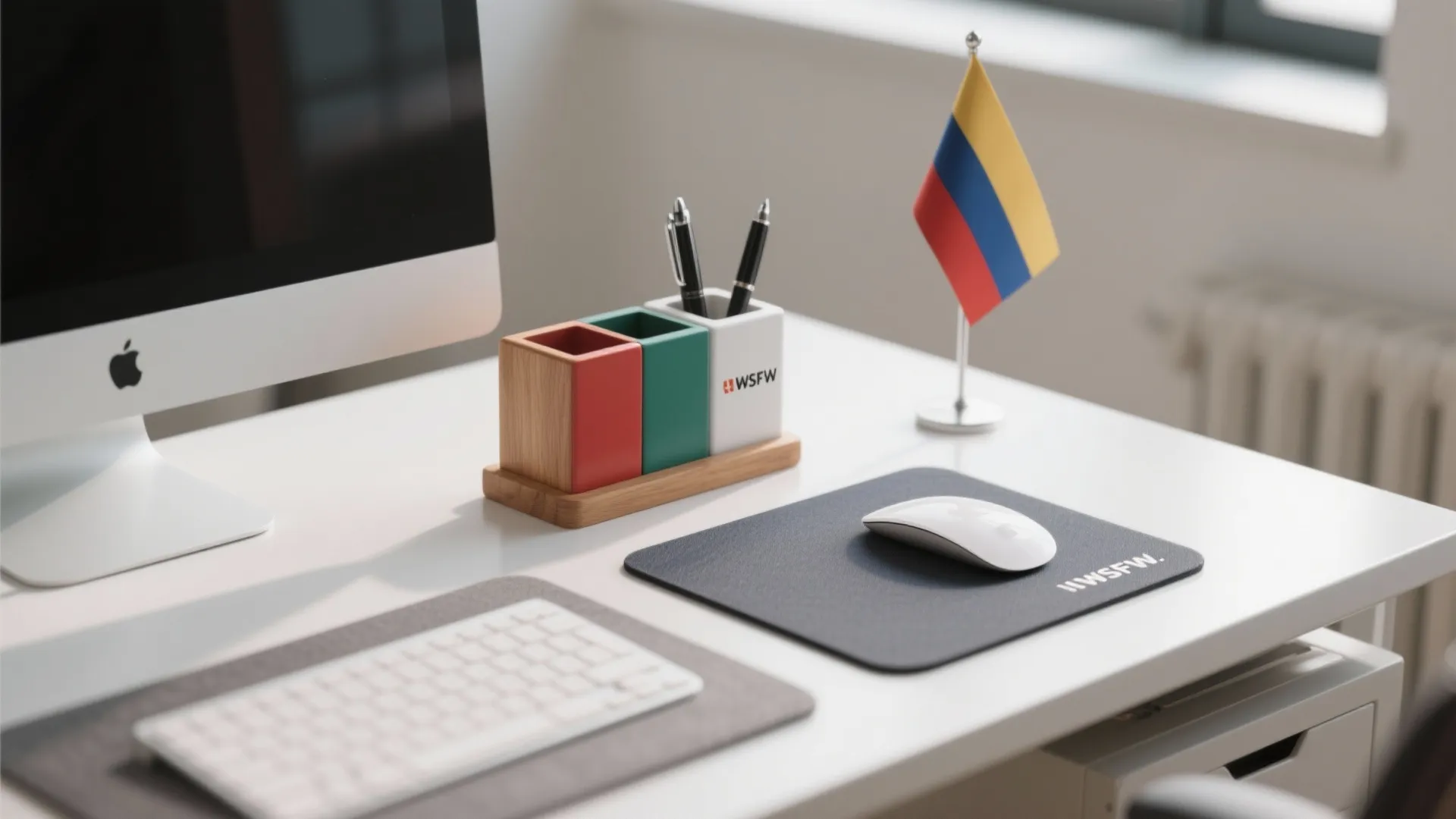Modern white office desk with computer monitor keyboard mouse pen holder and a small flag