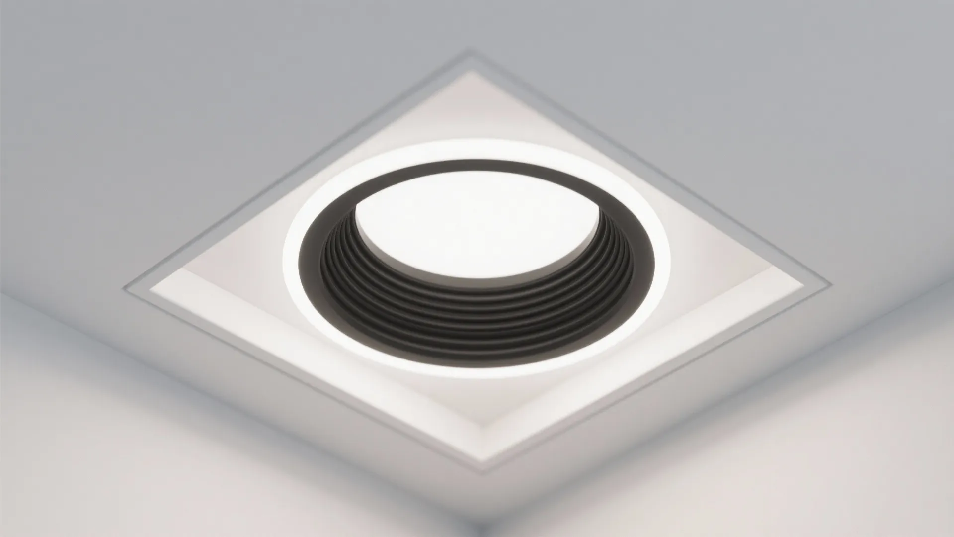 Close up view of a round black light fixture installed inside a square ceiling panel
