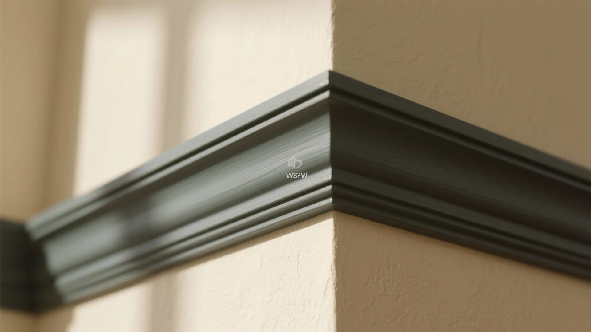 Close up of a dark green wall panel trim on a cream colored corner wall