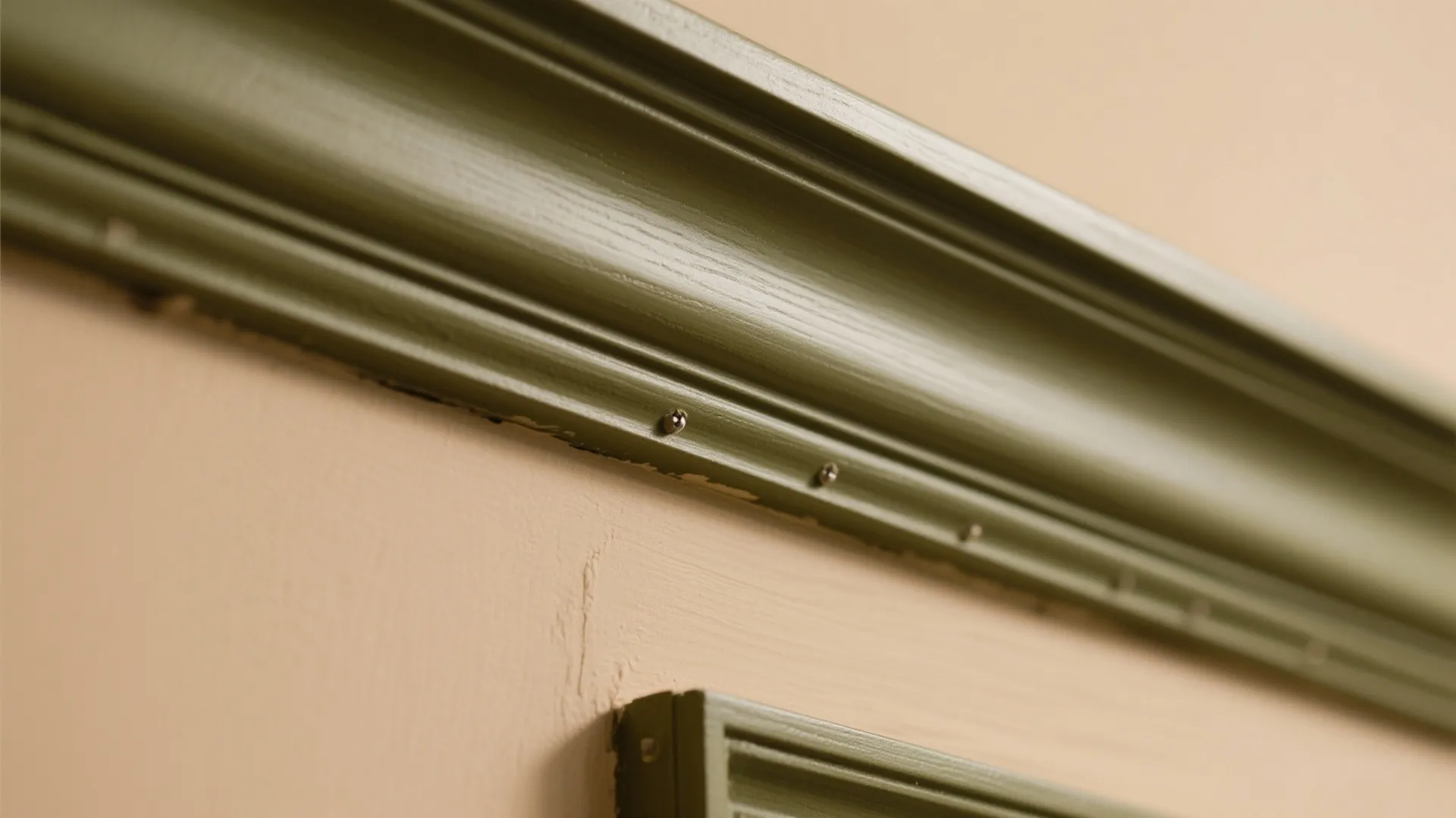 Close-up of olive trim against camel wall showing crisp paint preparation.