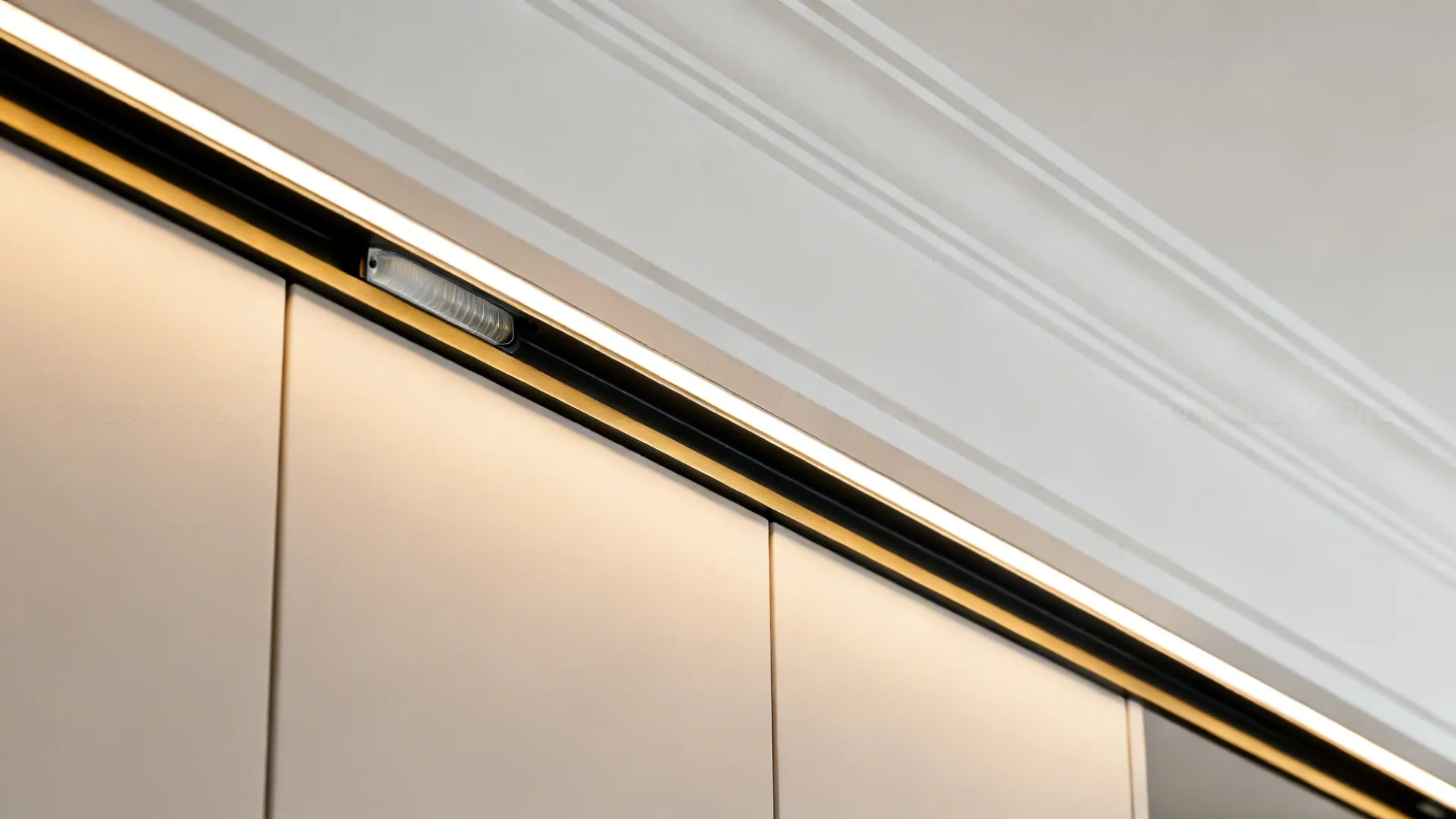Macro of gypsum edge with slim metal trim and hidden LED strip creating a smooth wall wash.