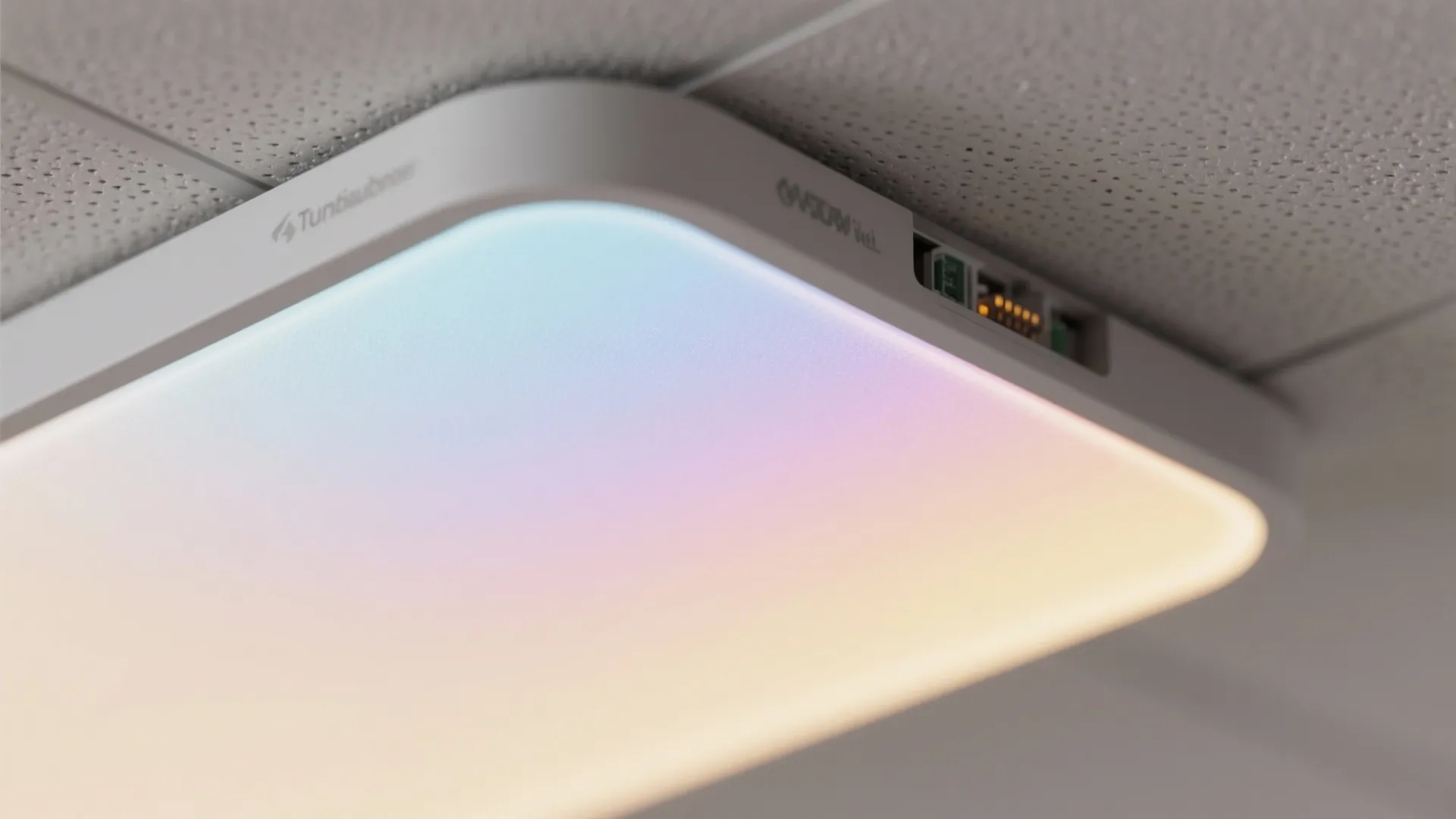 Close up view of a modern slim ceiling light fixture with colorful soft glowing light