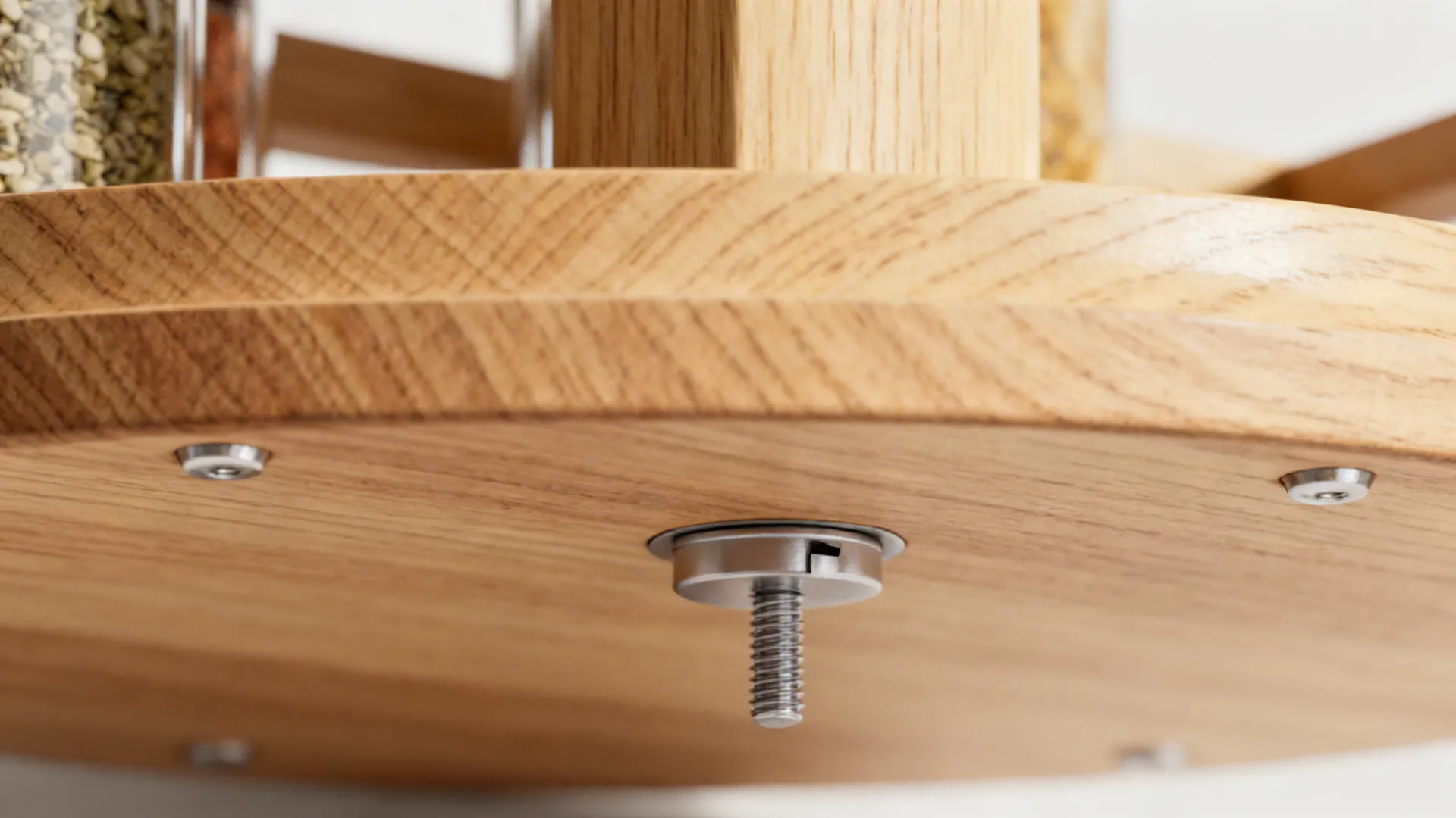 Close-up of a slim metal lazy Susan bearing under a wooden caddy.