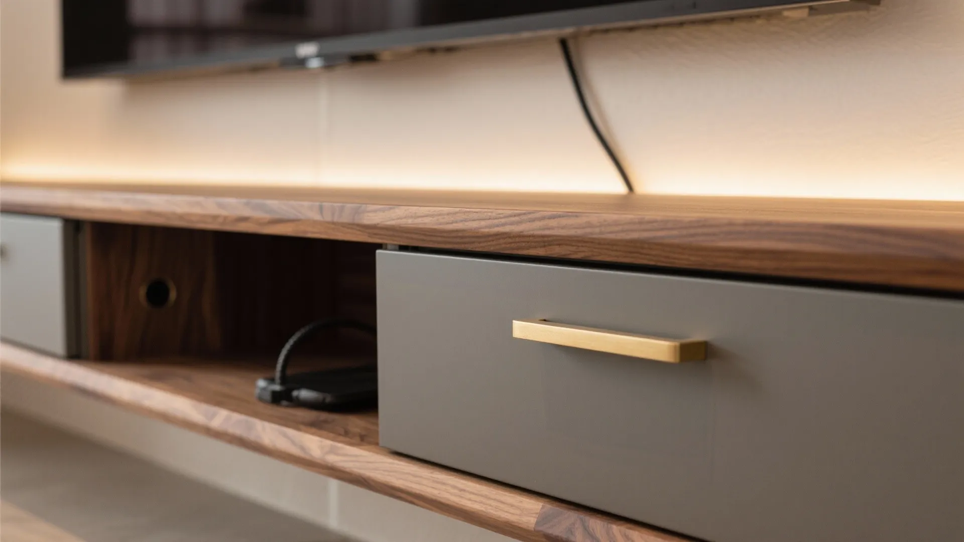 Modern wooden wall cabinet with a grey drawer golden handle and built-in light strip detail
