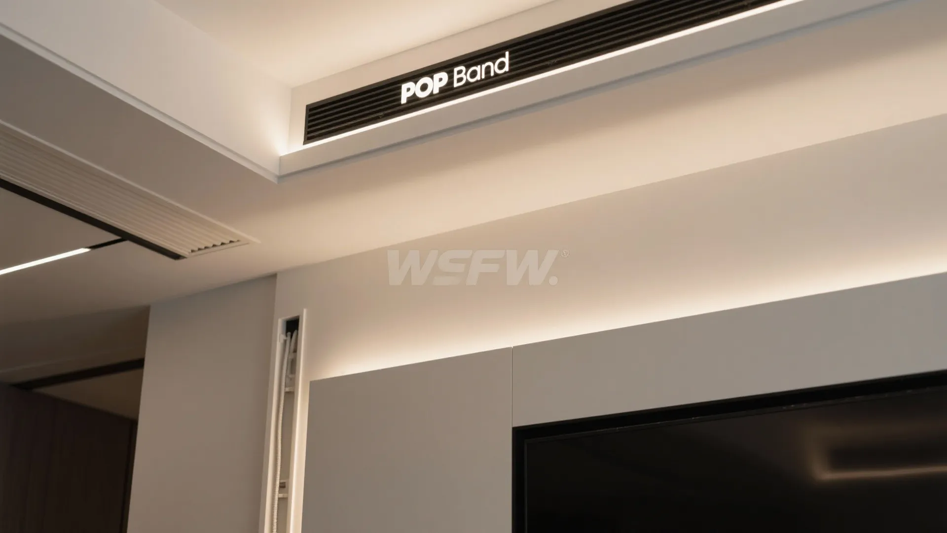 Close up of white ceiling and wall with black decorative band and hidden light fixture