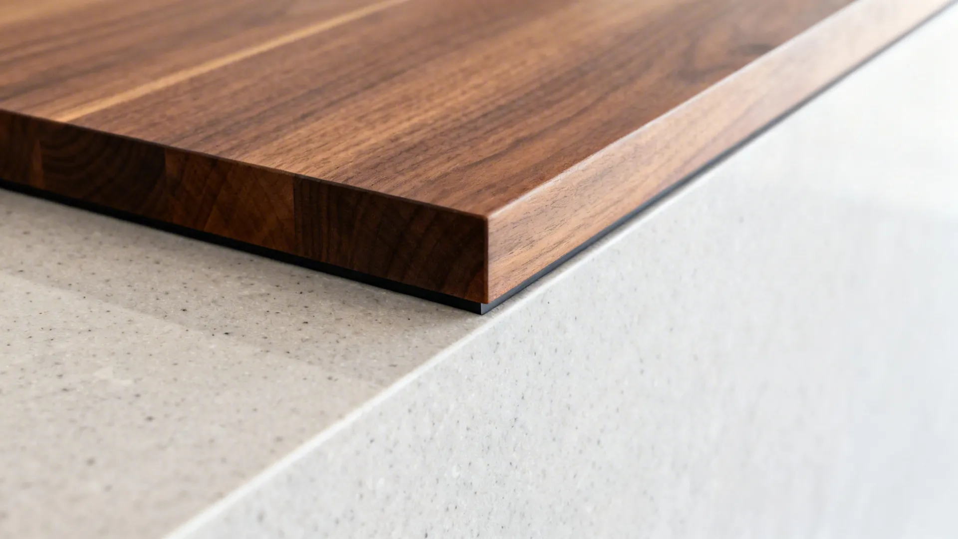 Close-up of a two-tier bar showing the clean transition between quartz and walnut with a slim waterfall edge.