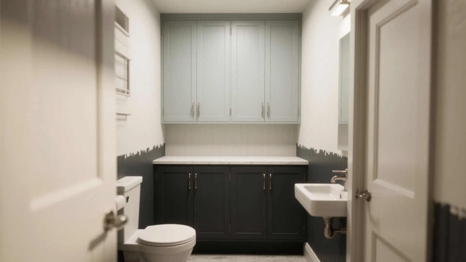 Modern small bathroom with blue upper cabinets dark lower cabinets white toilet and small white sink