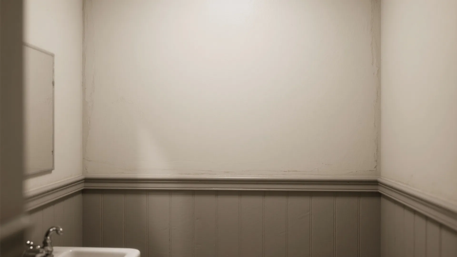 Neutral bathroom with grey wall panel white upper wall sink faucet and simple mirror frame