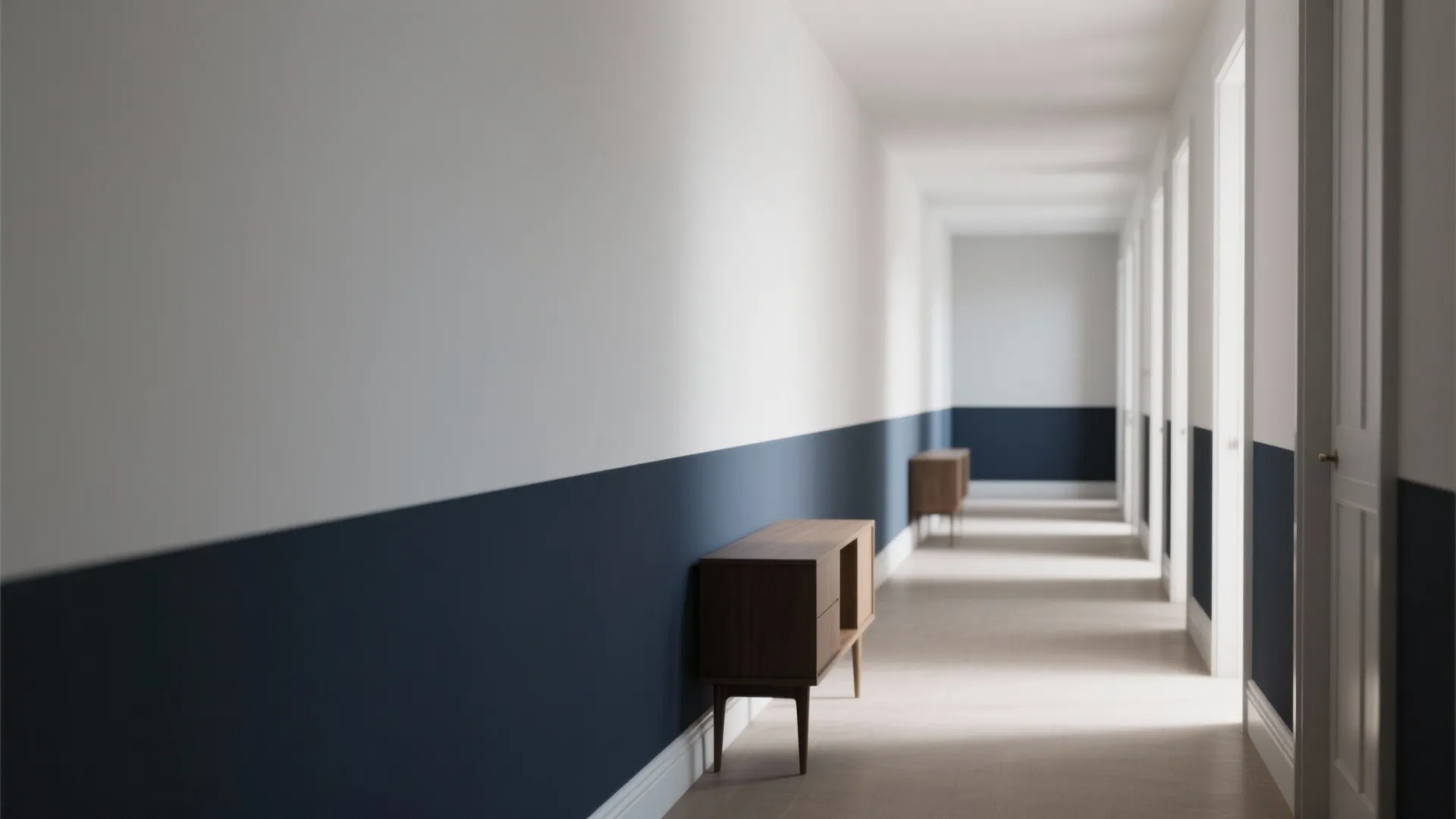 Long hallway with two-tone white and dark blue wall paint and small wooden storage cabinet