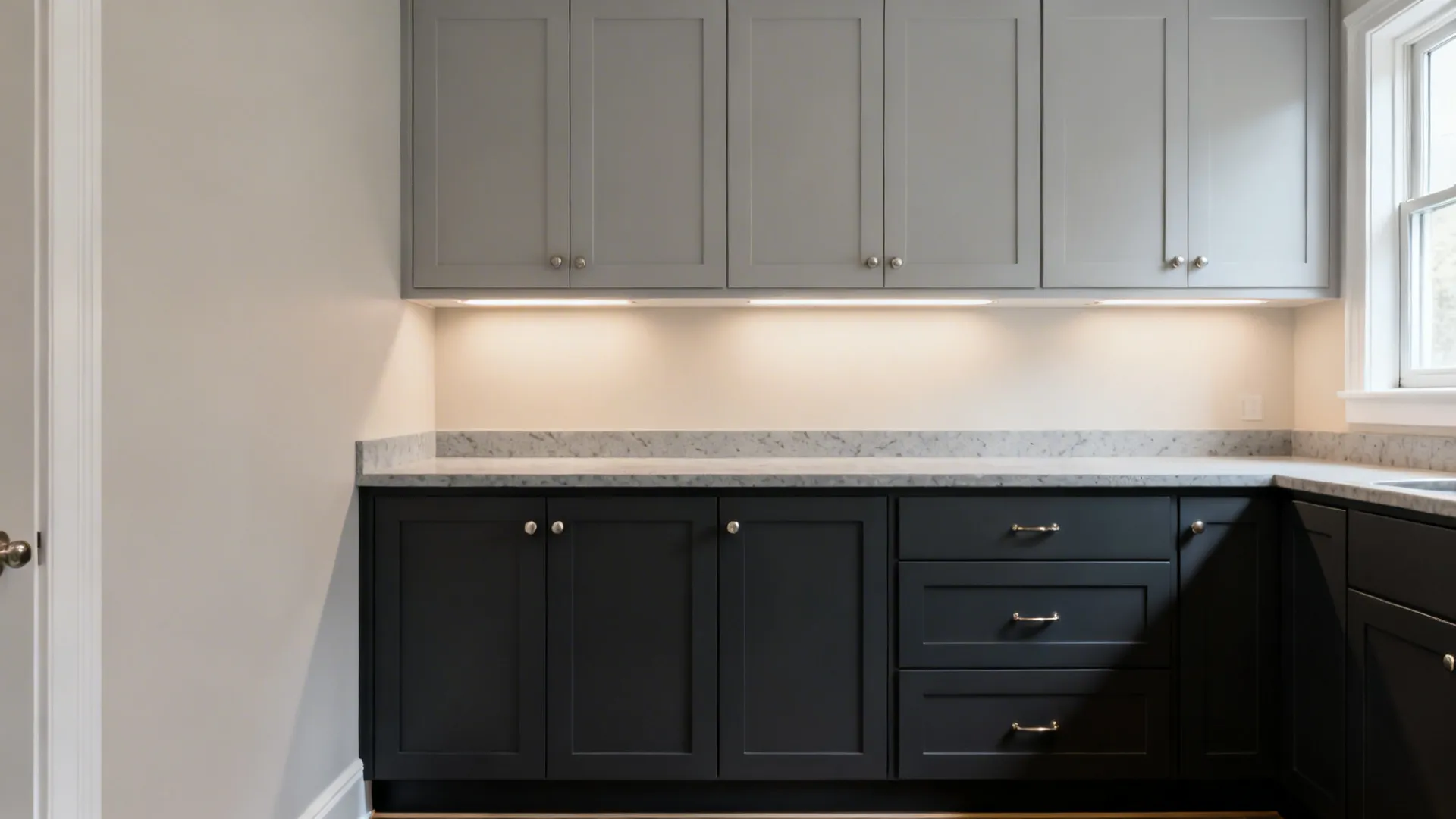 Two-tone kitchen with light grey uppers and charcoal base cabinets balancing height and weight.