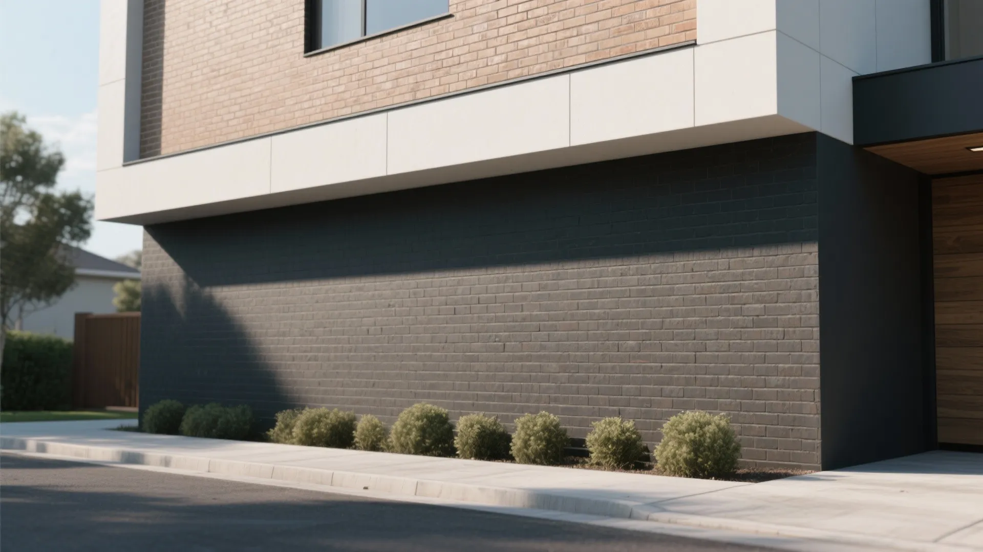 Modern house exterior with black brick bottom tan brick top small bushes and concrete sidewalk