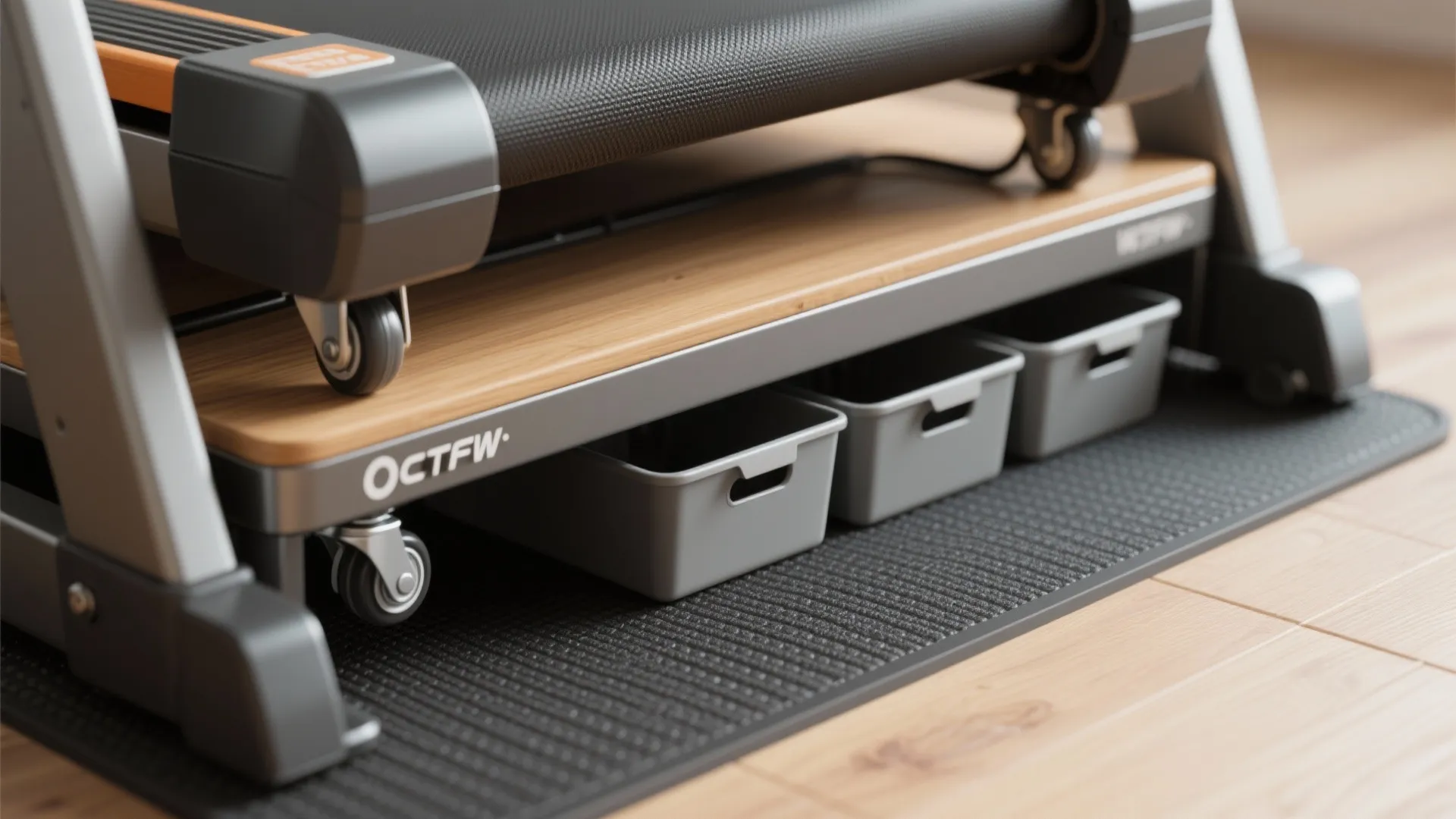 Gray storage bins placed on a wooden shelf underneath a black treadmill with small wheels