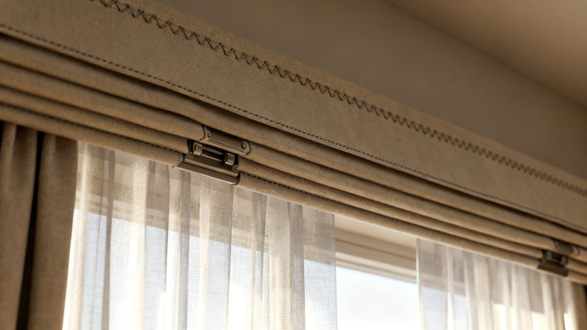 Close up of beige top curtain featuring decorative stitching and thin white fabric inner hanging curtains