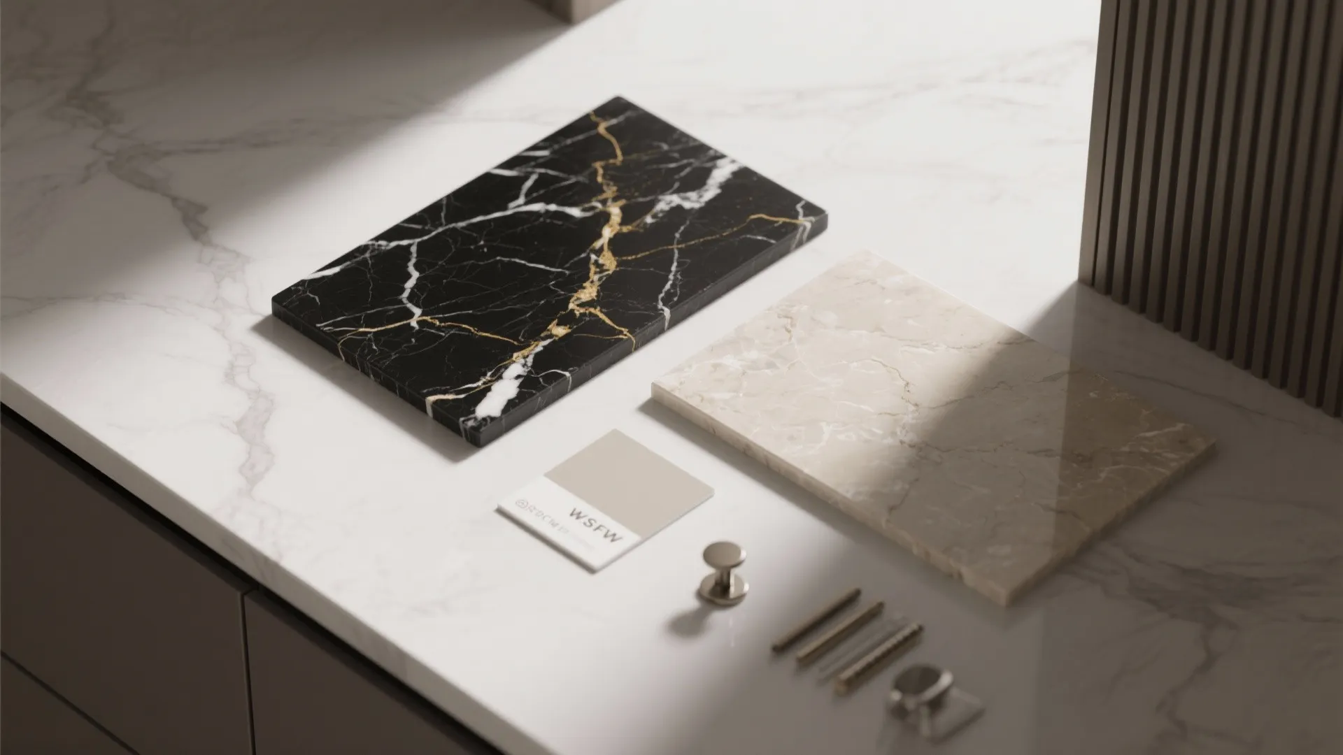 Interior design material board with black and white marble samples and metal cabinet hardware pieces