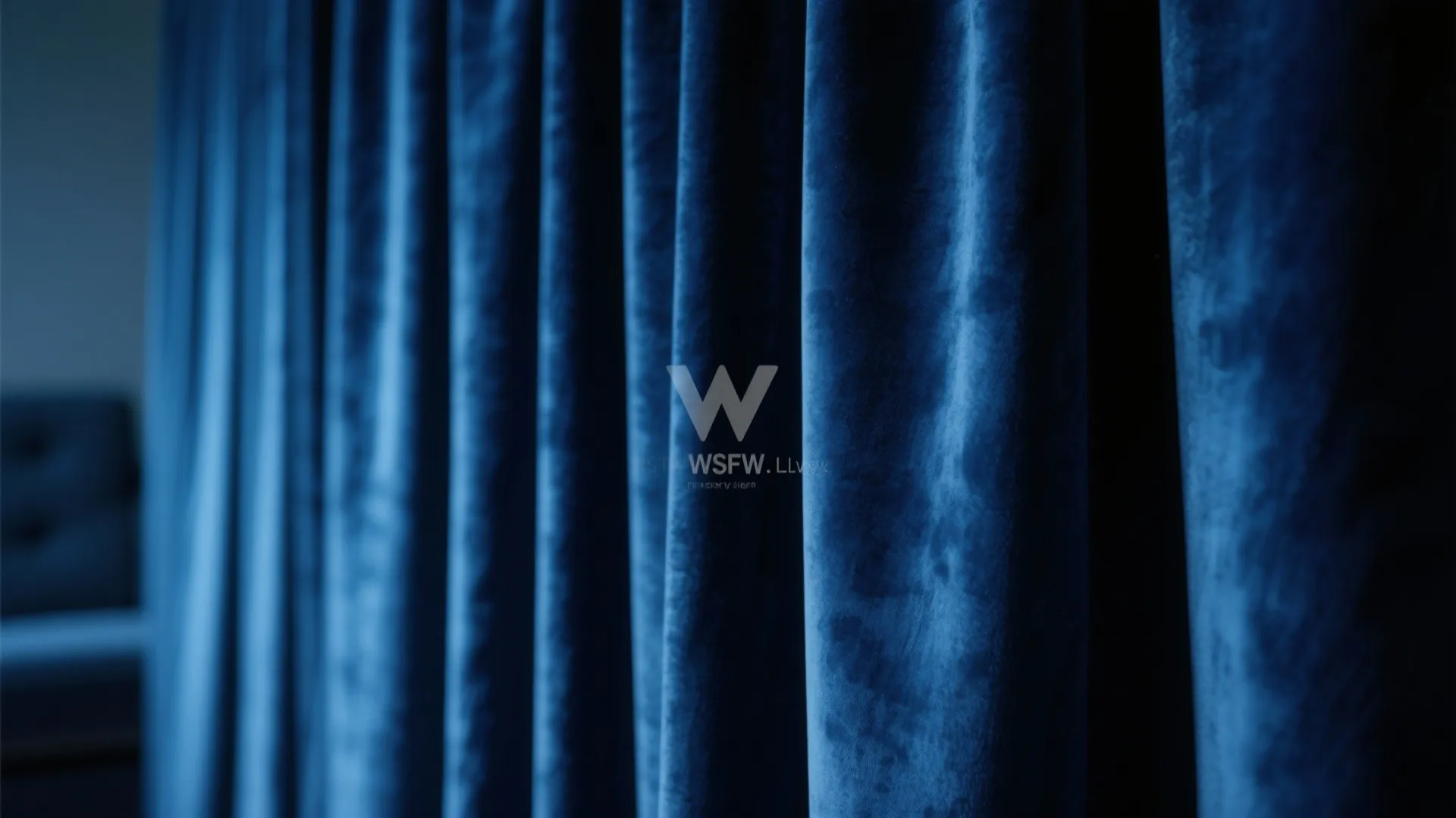 Close up view of soft blue velvet curtain fabric hanging in deep vertical wavy folds