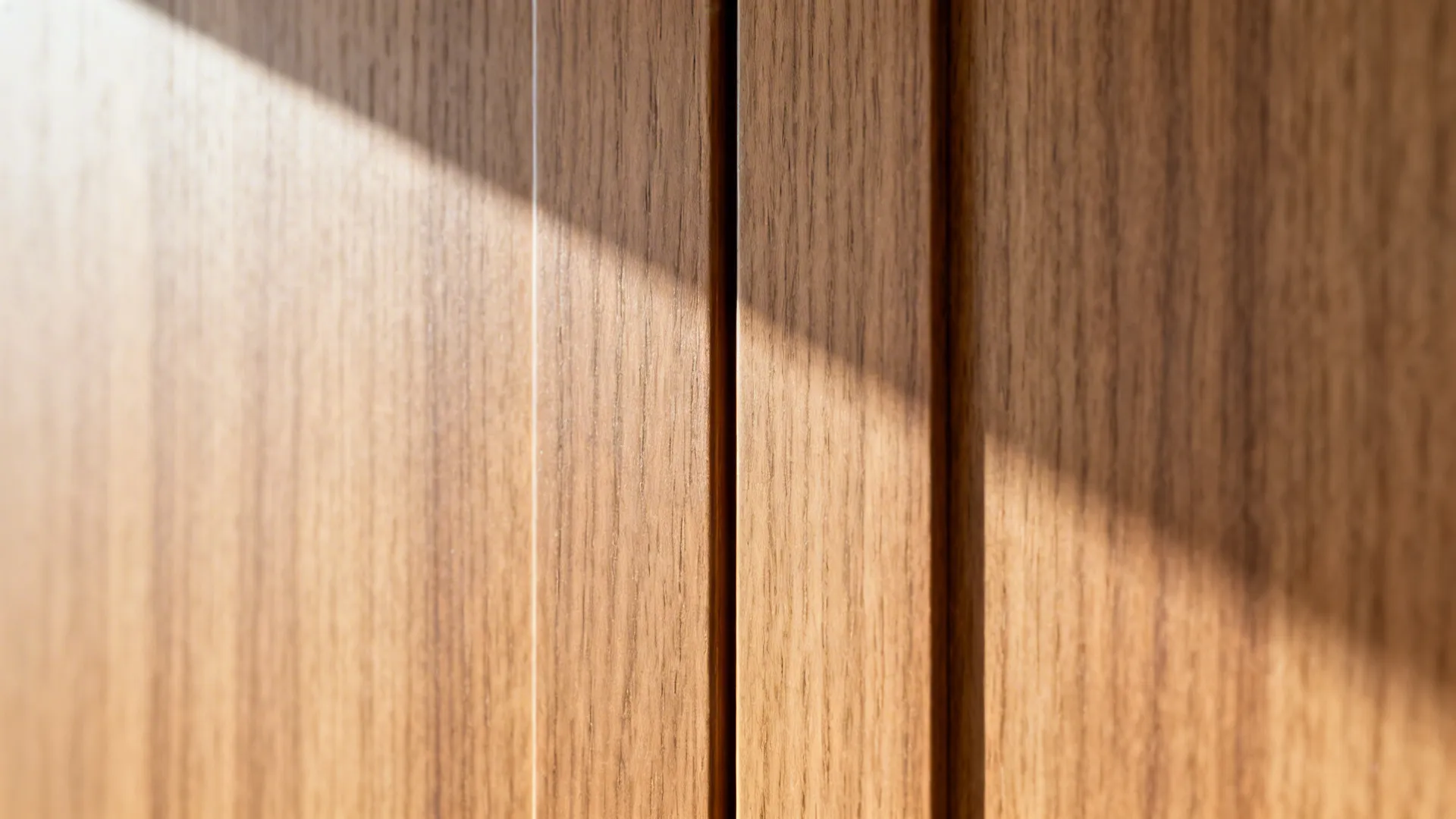 Macro detail of vertical-grain wood veneer with clean wrapped edge and satin finish.