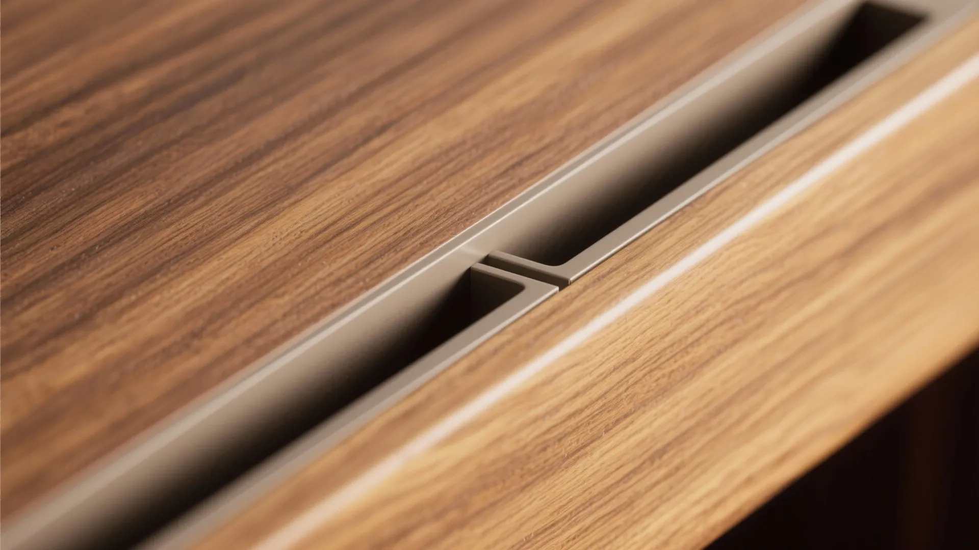 Close up of wood grain surface with thin metal handle on a modern brown cabinet